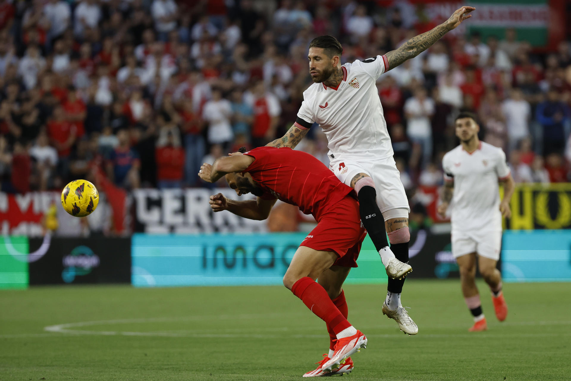El defensa español del Sevilla Sergio Ramos (d) disputa un balón con el delantero kosovar del Mallorca Vedat Muriqi (i) durante el partido de la jornada 32 de LaLiga celebrado este lunes en el estadio Sánchez Pizjuán de Sevilla. EFE/ Julio Muñoz