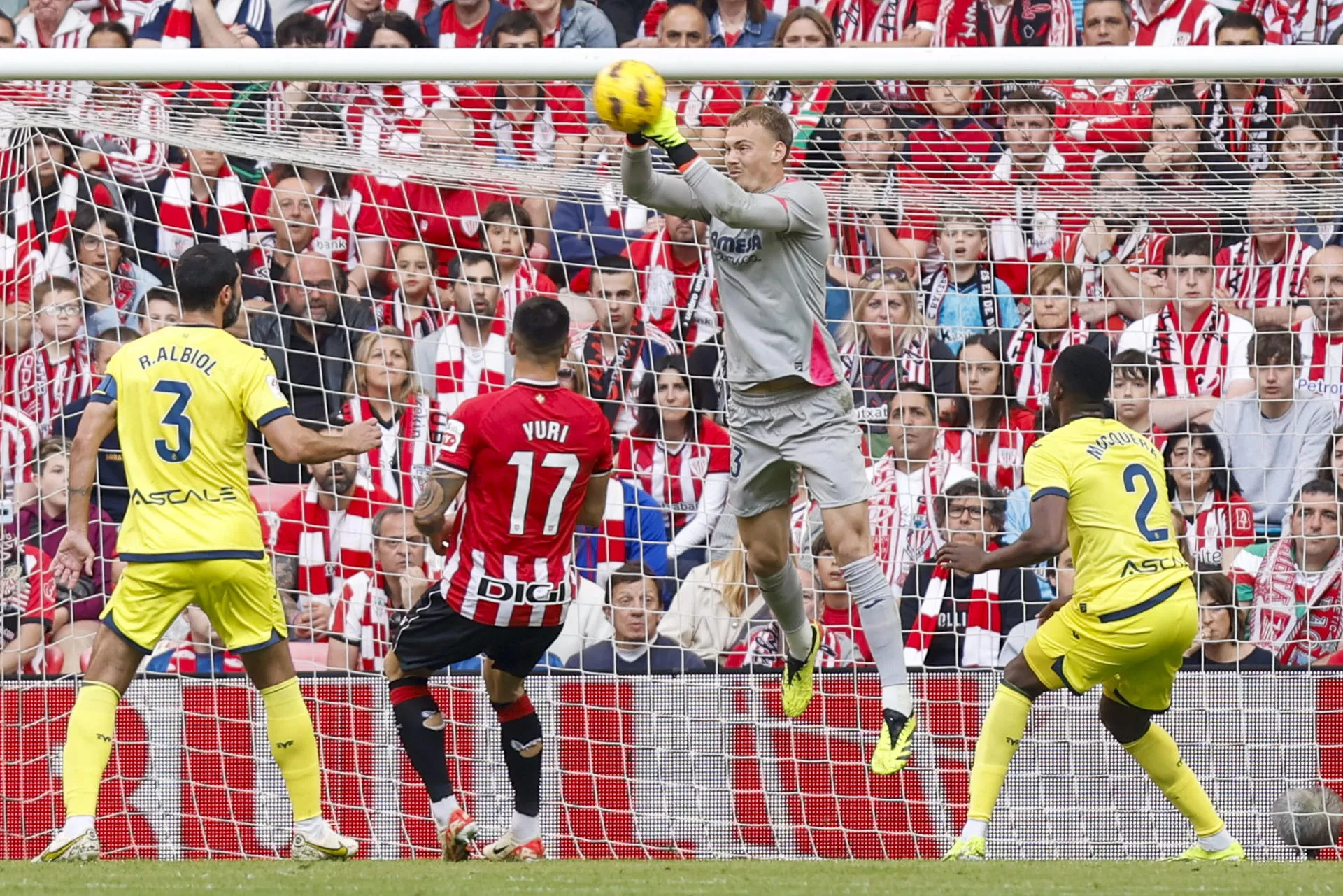 El portero sueco del Villarreal Filip Jörgensen (2-d) atrapa el balón durante el encuentro correspondiente a la jornada 31 de primera división que Athletic Club y Villarreal disputan hoy domingo en el estadio de San Mamés, en Bilbao. EFE / Miguel Toña. 