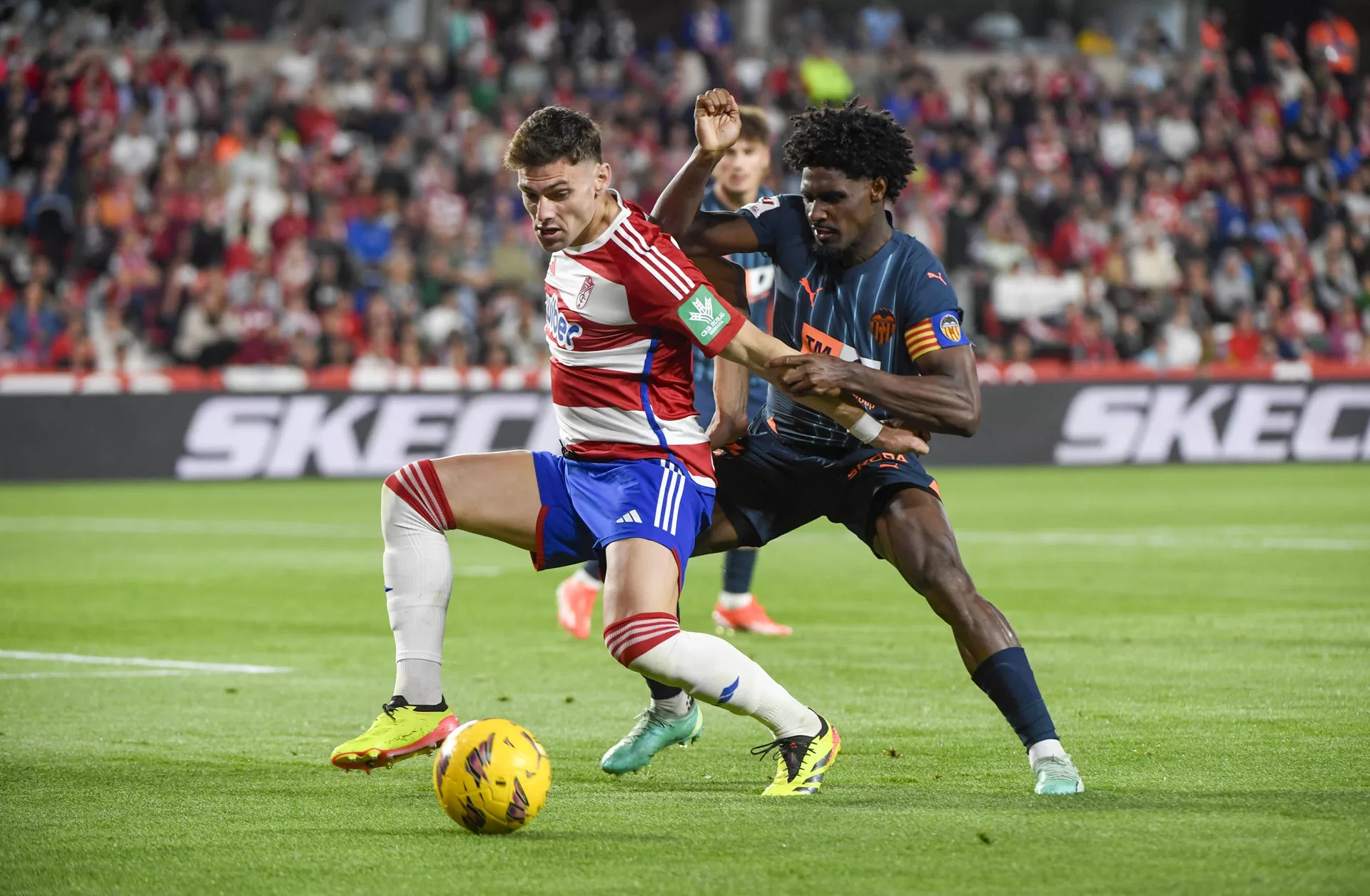 El delantero argentino del Granada Lucas(i) pelea un balón con el defensa portugués del Valencia Thierry Correia (d) durante el partido de LaLiga que Granada CF y Valencia CF disputan este jueves en el estadio Nuevo Los Cármenes. EFE/Miguel Ángel Molina