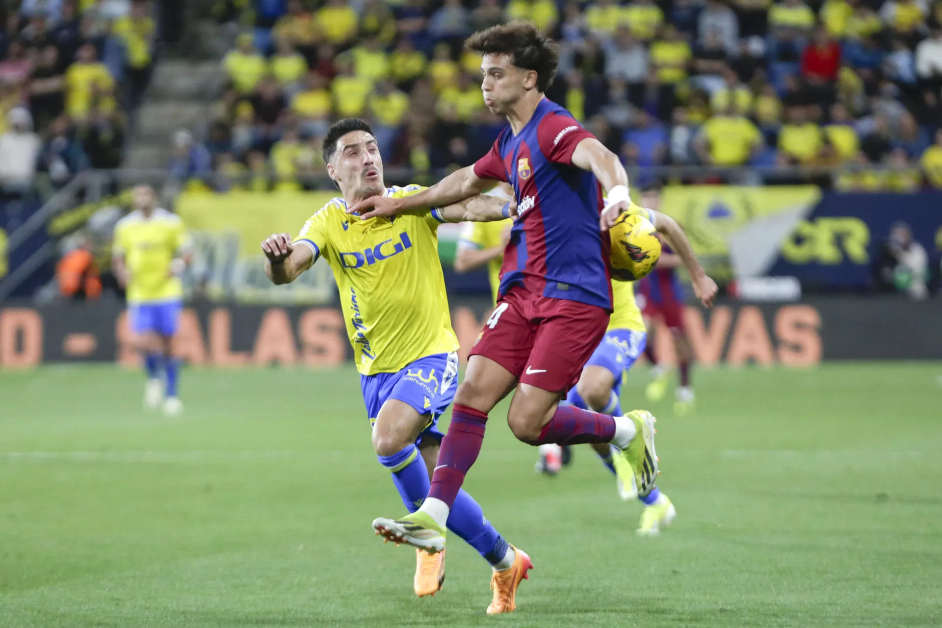El delantero del FC Barcelona Joao Félix (d) lucha por el balón con el el defensa del Cádiz CF Iza, durante el partido de Liga que enfrenta al Cádiz CF y al Barcelona CF en el estadio Nuevo Mirandilla, este sábado. EFE/Román Ríos.