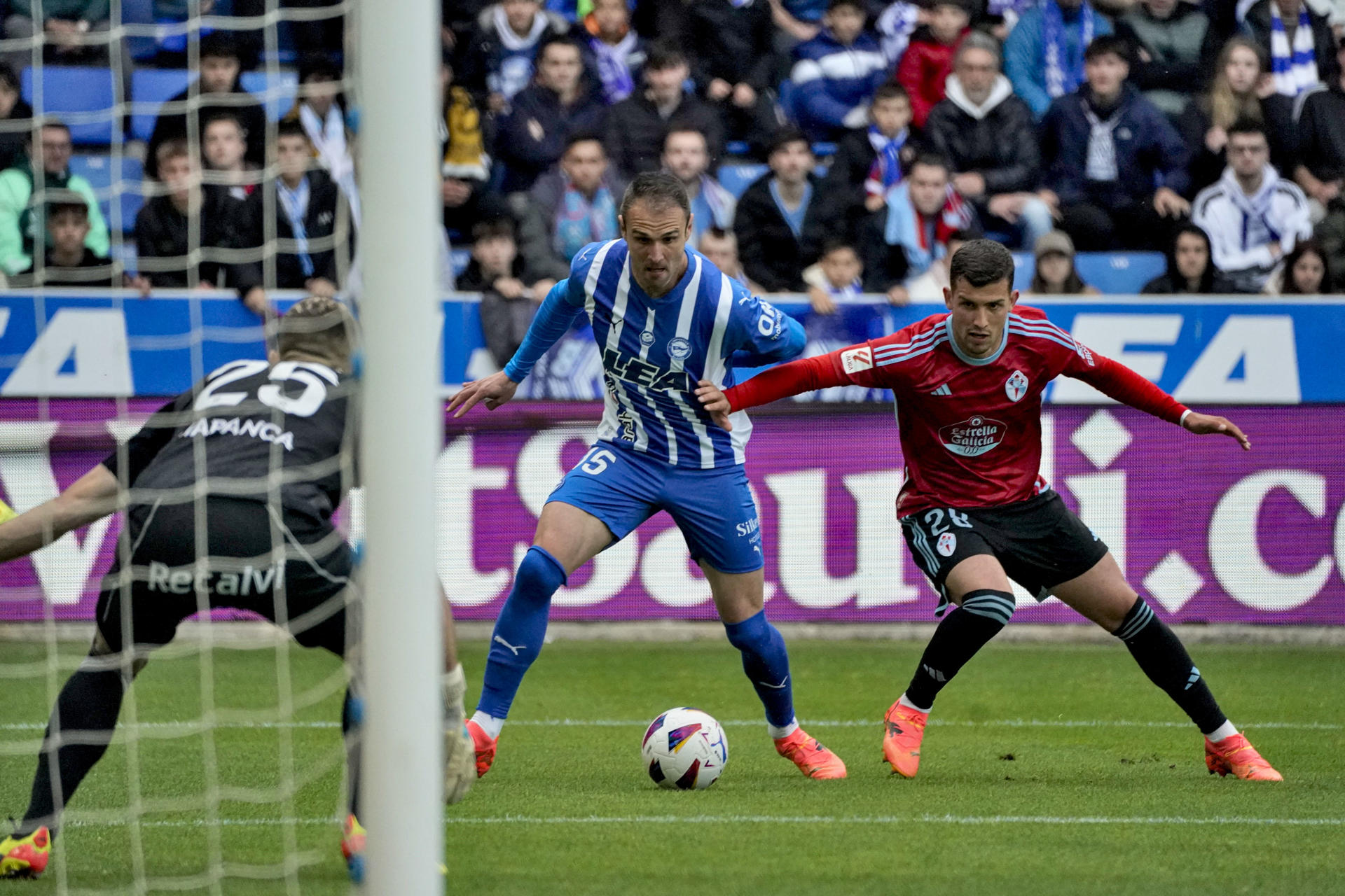 El delantero del Alavés Kike García (c) pelea un balón con el defensa del Celta Carlos Domínguez (d) durante el partido de LaLiga en el estadio de Mendizorroza. EFE / L. Rico 