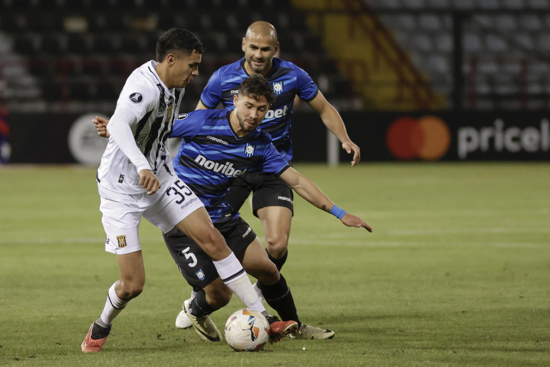 Felipe Loyola (c), del Huachipato de Chile, fue registrado este miércoles, 24 de abril, al disputar un balón con Daniel Jhonatan Lino (i), del The Strongest de Bolivia, durante un partido del grupo C de la Copa Libertadores, en el estadio Huachipato en el estadio Huachipato-CAP Acero de Talcahuano (Chile). EFE/Esteban Paredes 