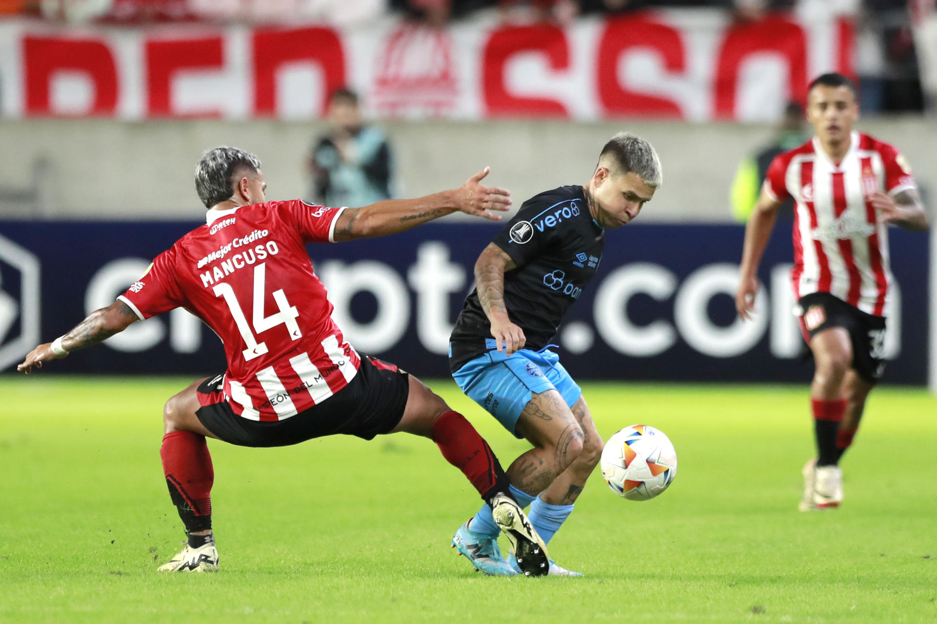 Eros Mancuso (i), de Estudiantes, disputa el balón con el venezolano Yeferson Soteldo, de Gremio, en el partido de la tercera jornada  del Grupo C de la Copa Libertadores jugado este martes en el estadio Jorge Luis Hirsci de la ciudad argentina de La Plata. EFE/ Demian Alday Estevez