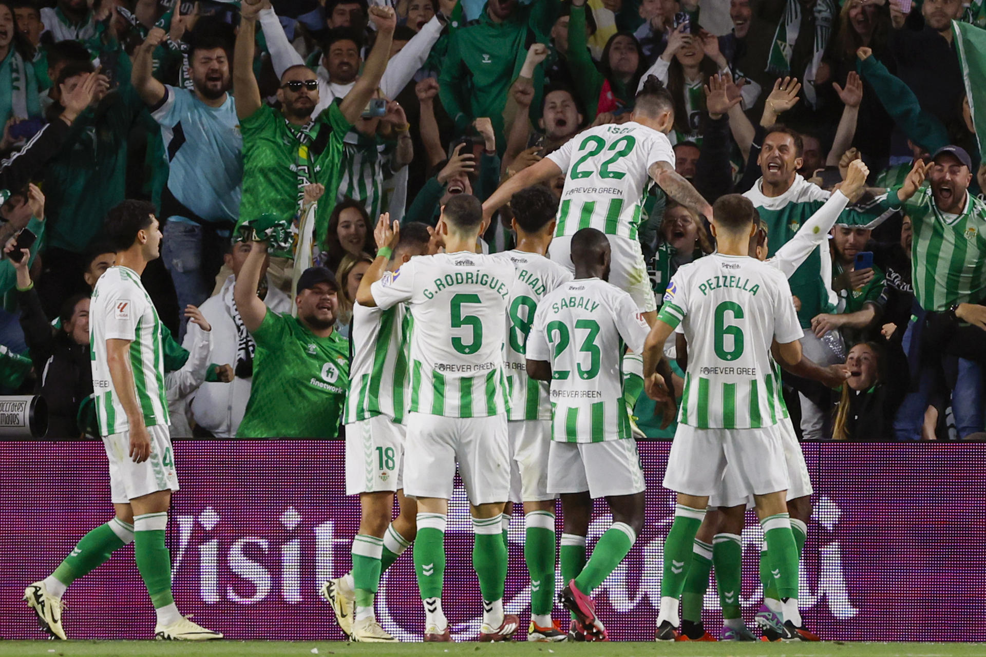 El centrocampista del Betis Francisco Alarcón 'Isco' (arriba) celebra con sus compañeros tras marcar ante el Sevilla, durante el partido de Liga en Primera División en el estadio Benito Villamarín. EFE/Julio Muñoz 
