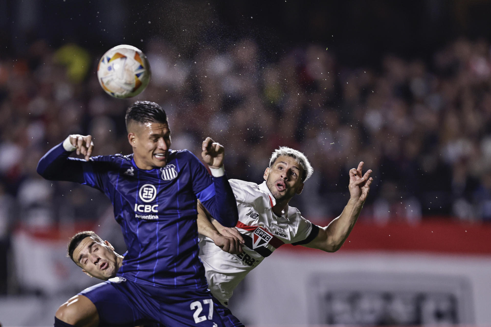 El delantero argentino del Sao Paulo, Jonathan Calleri (d), disputa el balón con su compatriota de Talleres Juan Portilla (c) durante el partido de la última jornada de la fase de grupos de la Copa Libertadores jugado este miércoles en el estadio Morumbi. EFE/ Isaac Fontana 