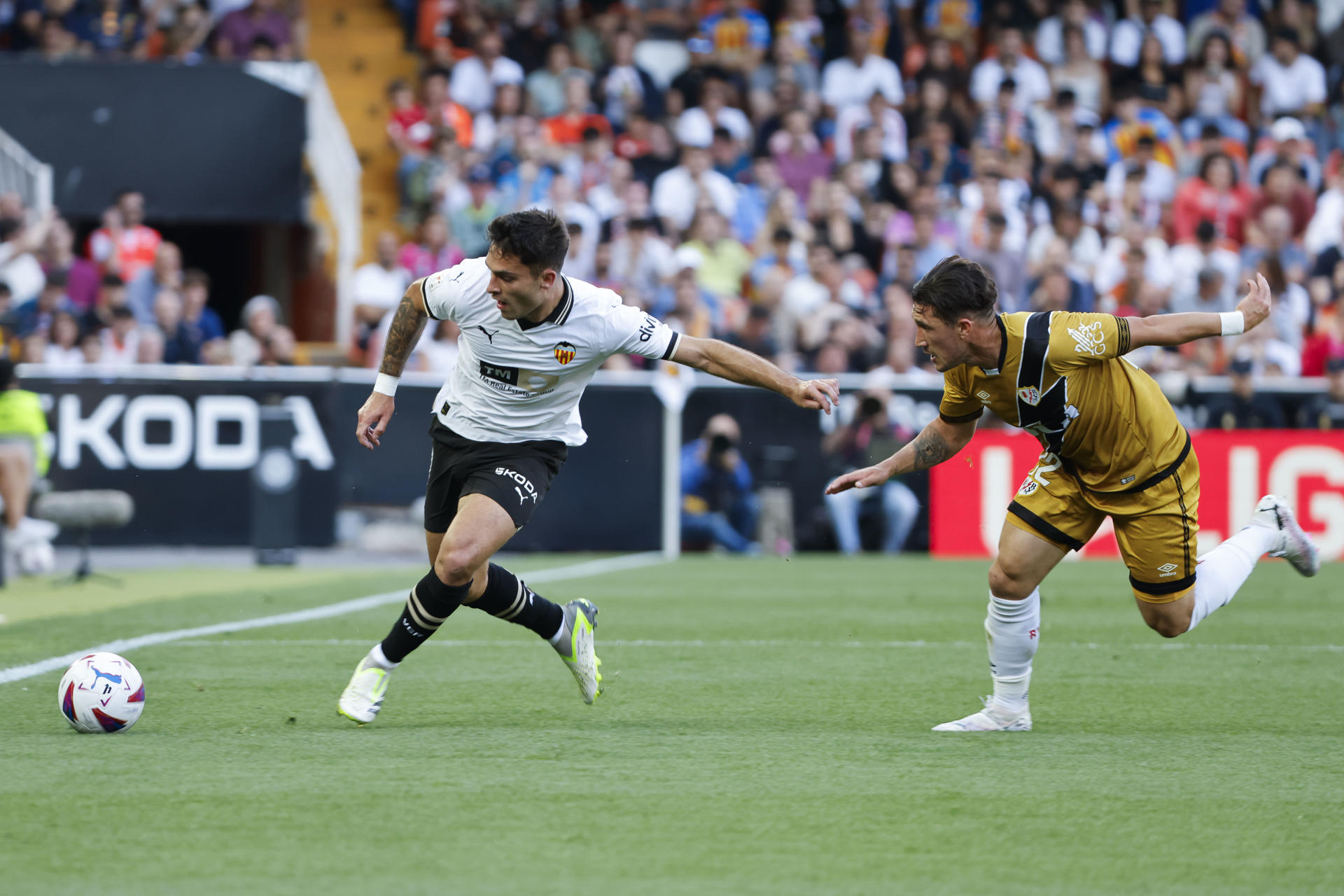 El delantero del Valencia Hugo Duro (i) pelea un balón con Luis Espino, del Rayo Vallecano, durante el partido de LaLiga entre el Valencia y el Rayo Vallecano, este domingo en el estadio de Mestalla. EFE/ Ana Escobar 