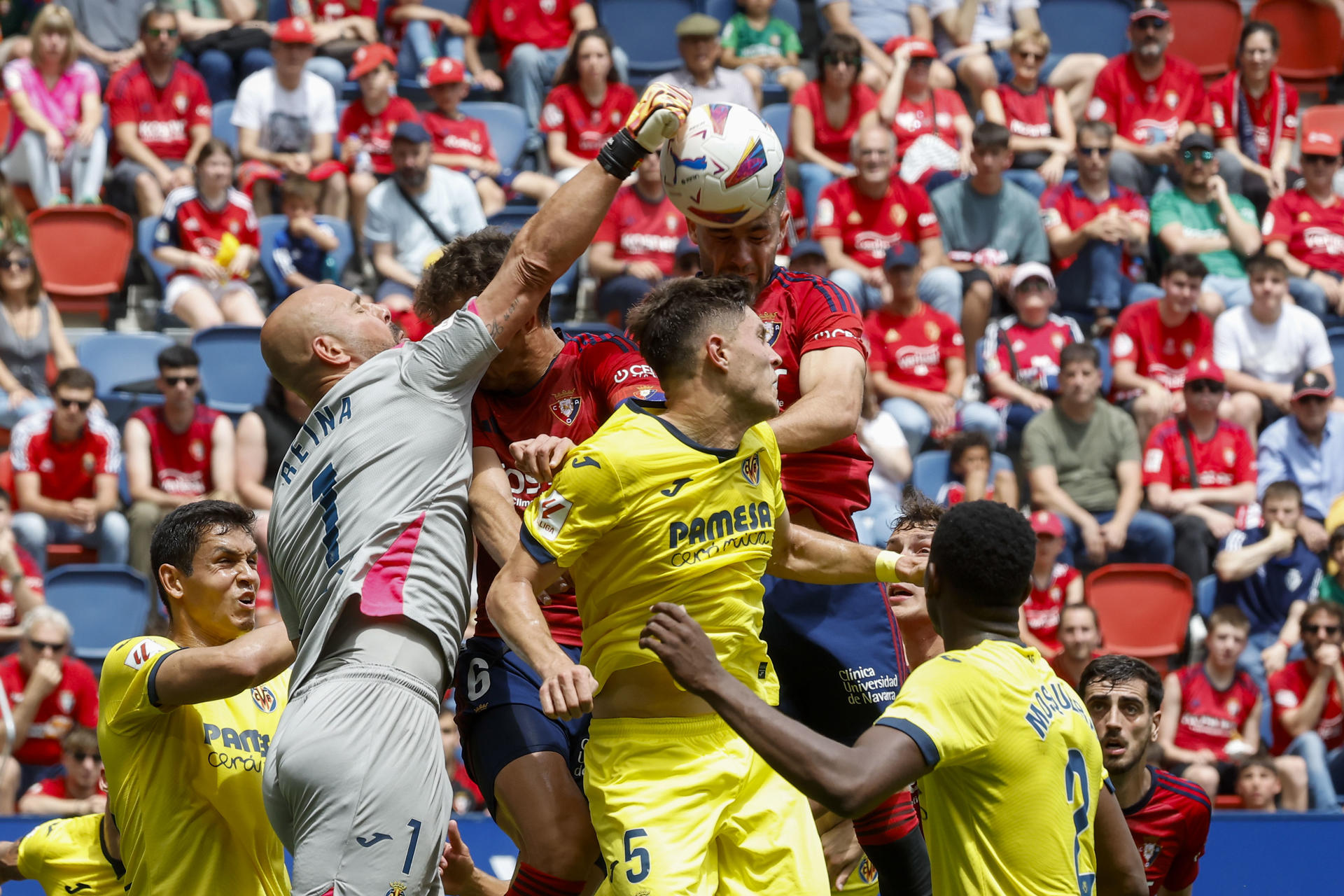 El portero del Villarreal Pepe Reina (i) despeja el balón ante los jugadores del Osasuna durante el partido de la última jornada de LaLiga entre el Osasuna y Villarreal, este sábado en el estadio de El Sadar en Pamplona.-. EFE/Villar López
