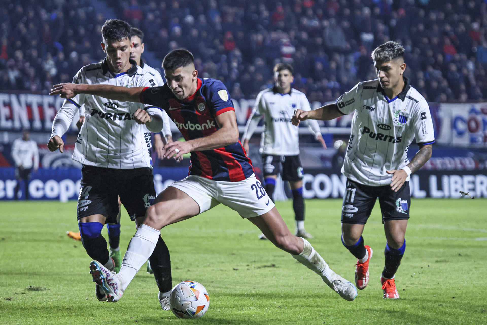 Alexis Cuello (c) de San Lorenzo disputa el balón con Jean Rosso (i)de Liverpool en un partido de la fase de grupos de la Copa Libertadores. EFE/ Luciano González 