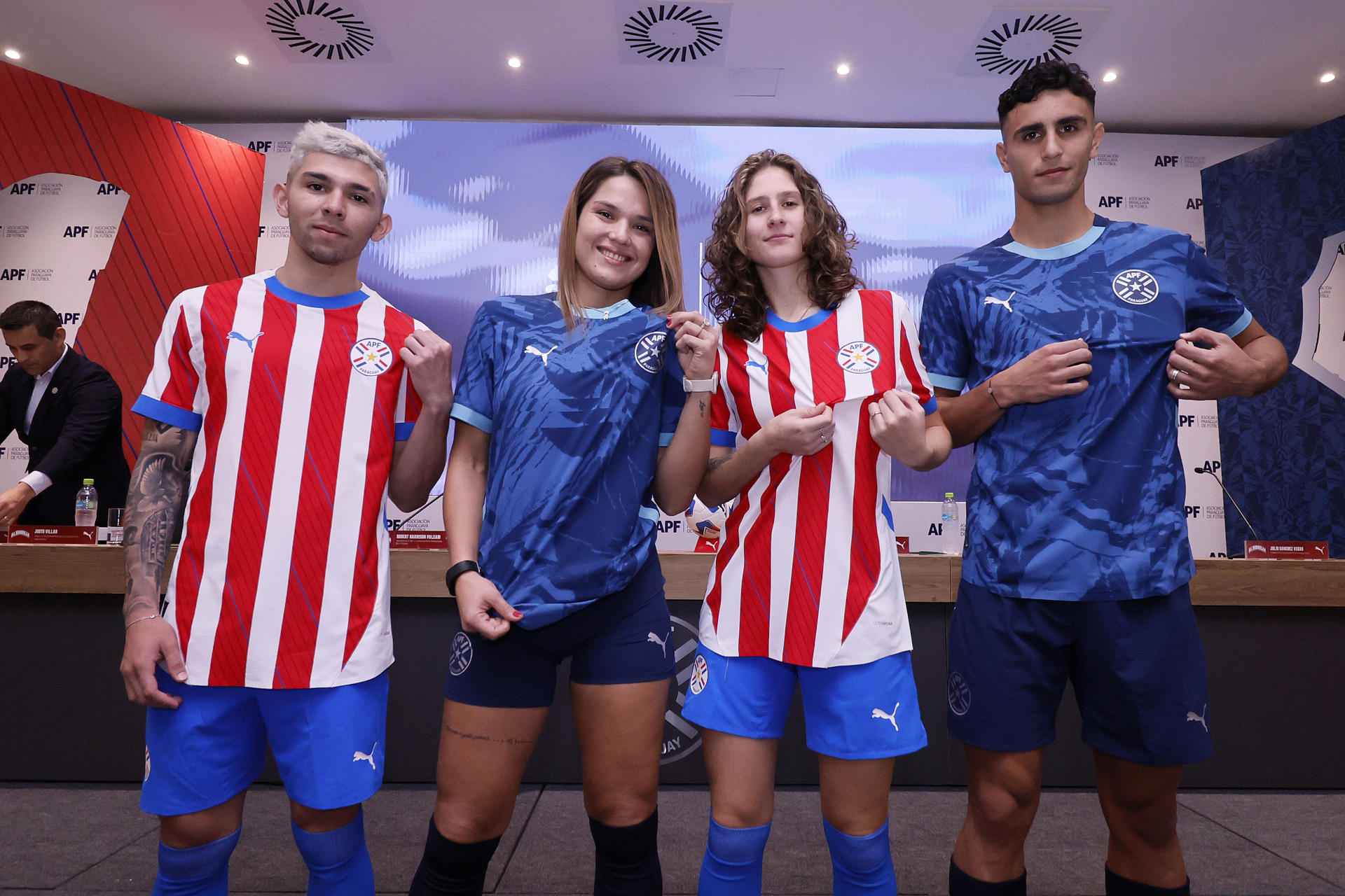 Fotografía cedida este lunes, 27 de mayo, por la Asociación Paraguaya de Fútbol en la que se registró a los futbolistas Julio Enciso (i), Paola Genes (2i),Camila Barbosa (2d) y Kevin Parzajuk, mientras lucen las nuevas camisetas que la selección paraguaya de fútbol usará en la Copa América de Estados Unidos. EFE/Asociación Paraguaya de Fútbol 