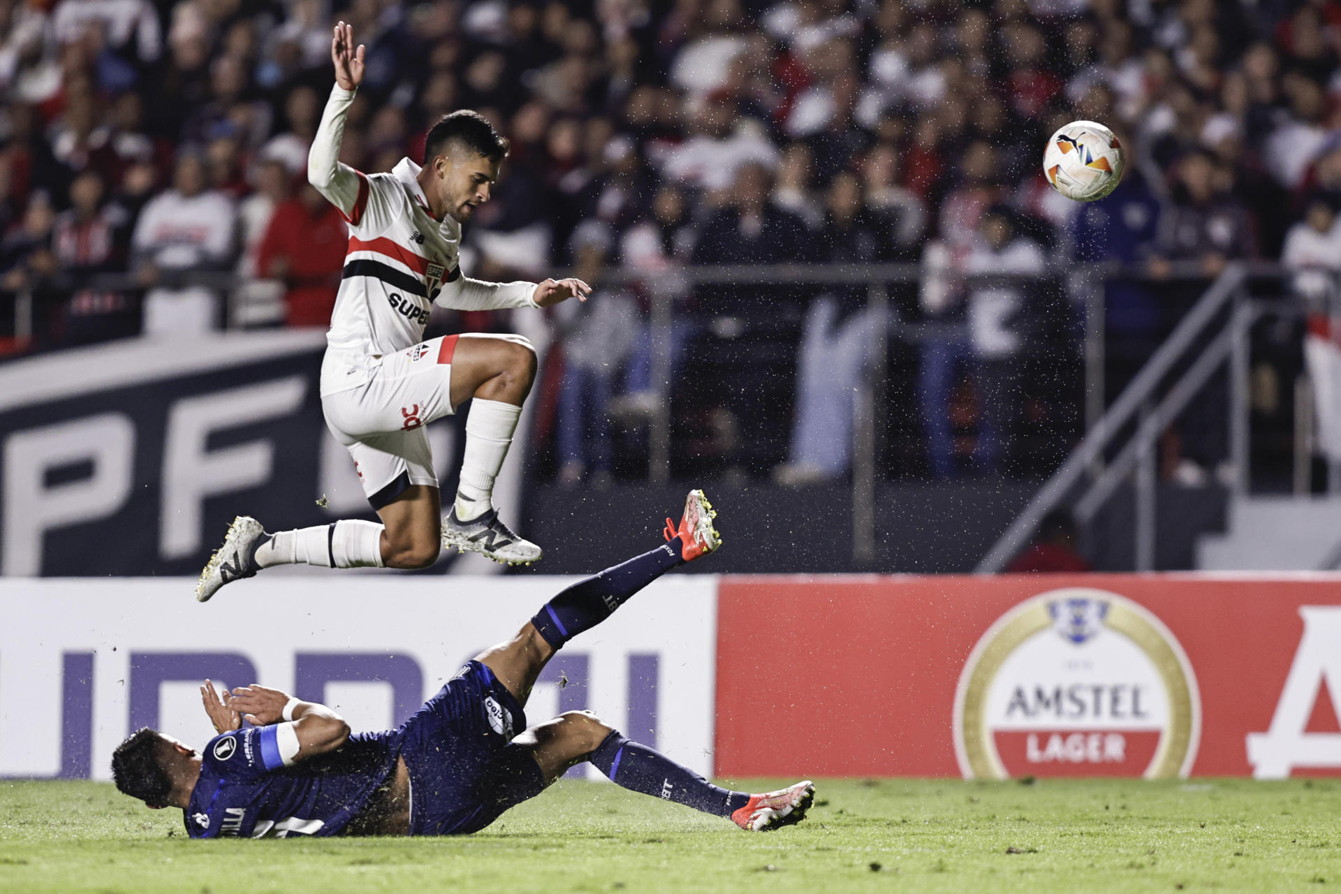 El centrocampista de Sao Paulo Rodrigo Nestor (arriba) elude la marca de Kevin Mantilla, de Talleres, este miércoles, durante el partido de cierre de la fase de grupos de la Copa Libertadores que el equipo brasileño ganó por 2-0 al argentino en el estadio Morumbi. EFE/ Isaac Fontana 