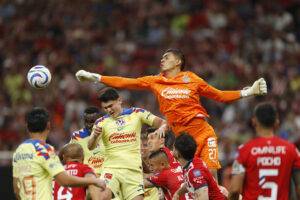 Raúl Rangel (d) guardameta del Guadalajara disputa el balón con Israel Reyes de América este miércoles, durante un partido de las semifinales del torneo clausura 2024 de la Liga Mx, disputado en el Estadio Akron en la ciudad de Guadalajara (México). EFE/ Francisco Guasco