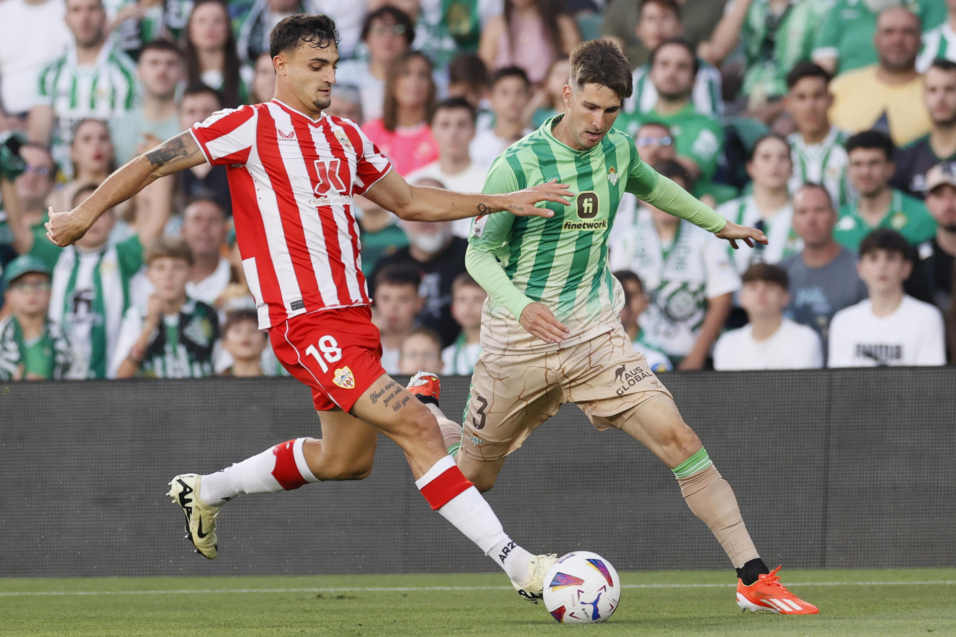El defensa del Betis Juan Miranda (d) lucha con Marc Pubill, del Almería, durante el partido de LaLiga en el estadio Benito Villamarín, en Sevilla. EFE/José Manuel Vidal 