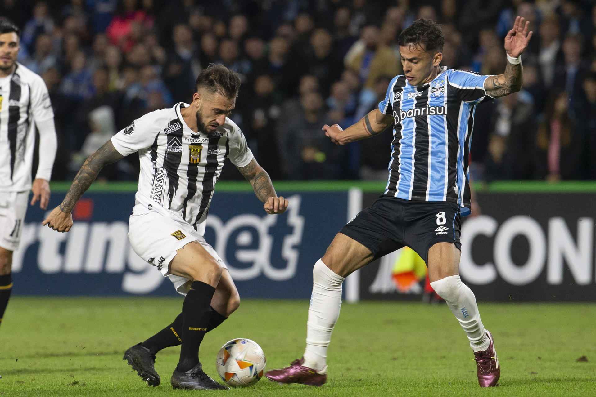 Felipe Carballo (d) de Gremio disputa un balón con Luciano Ursino de The Strongest en un partido de la Copa Libertadores en el estadio Couto Pereira, en Curitiba (Brasil). EFE/Hedeson Alves 
