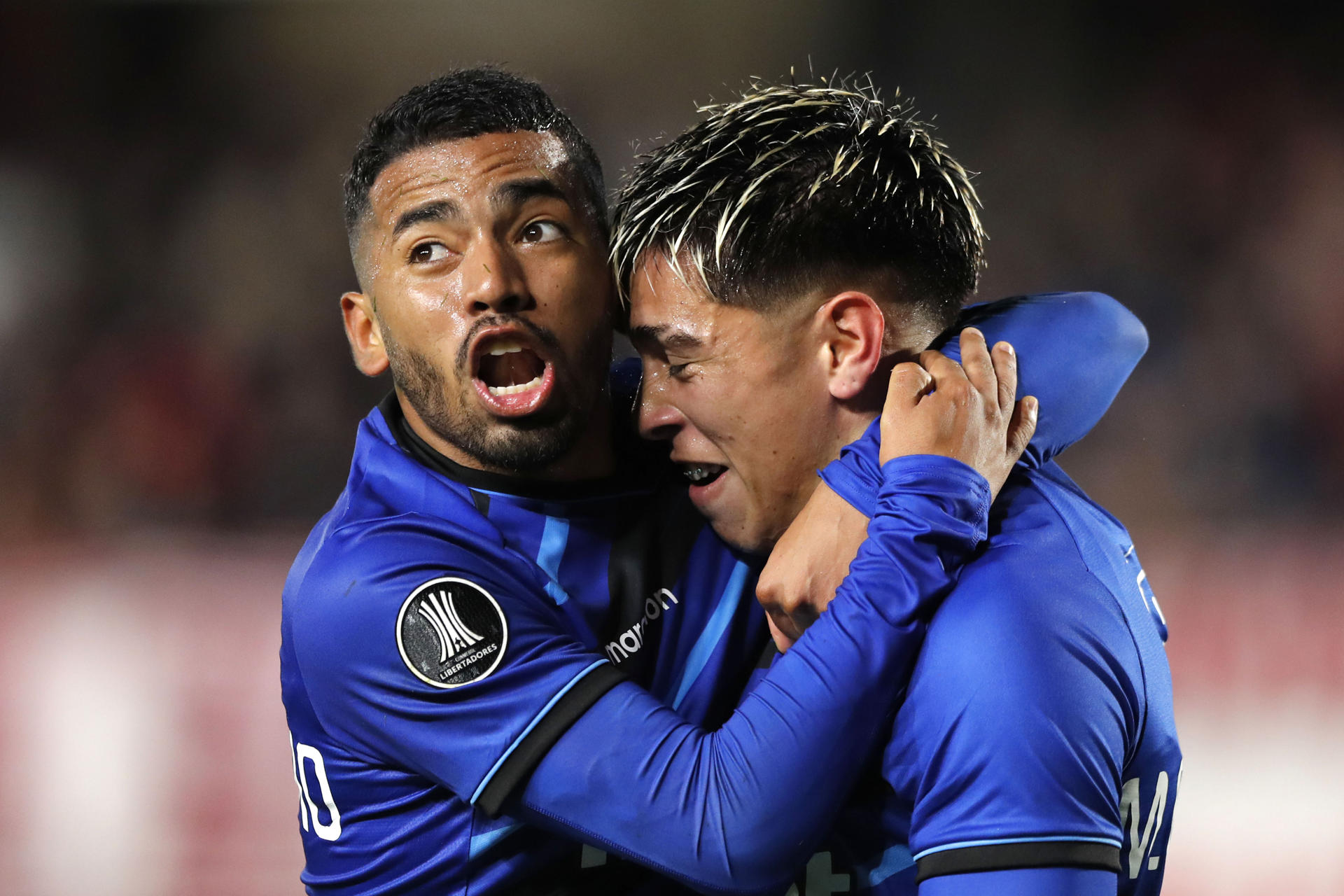 Brayan Palmezano (i) y Maximiliano Gutiérrez, de Huachipato, fueron registrados este miércoles, 29 de mayo, al celebrar un gol que Estudiantes anotó en propia puerta, durante un partido del grupo C de la Copa Libertadores, en el estadio Jorge Luis Hirschi de La Plata (Argentina). EFE/Demián Estevez 