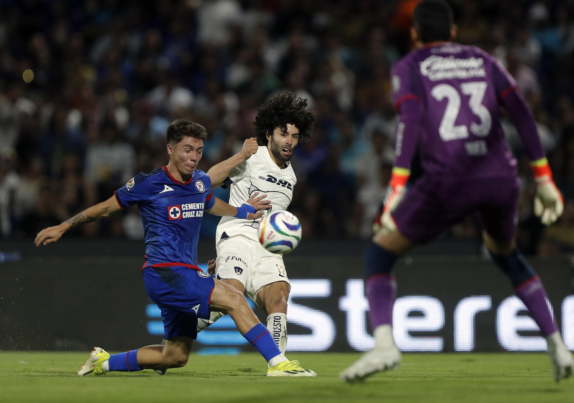 César Huerta (c) de Pumas disputa un balón con Rodrigo Huescas (i) de Cruz Azul durante un juego de ida de los cuartos de final de la Liga MX, celebrado en el estadio Olímpico Universitario de la Ciudad de México (México). EFE/Isaac Esquivel 