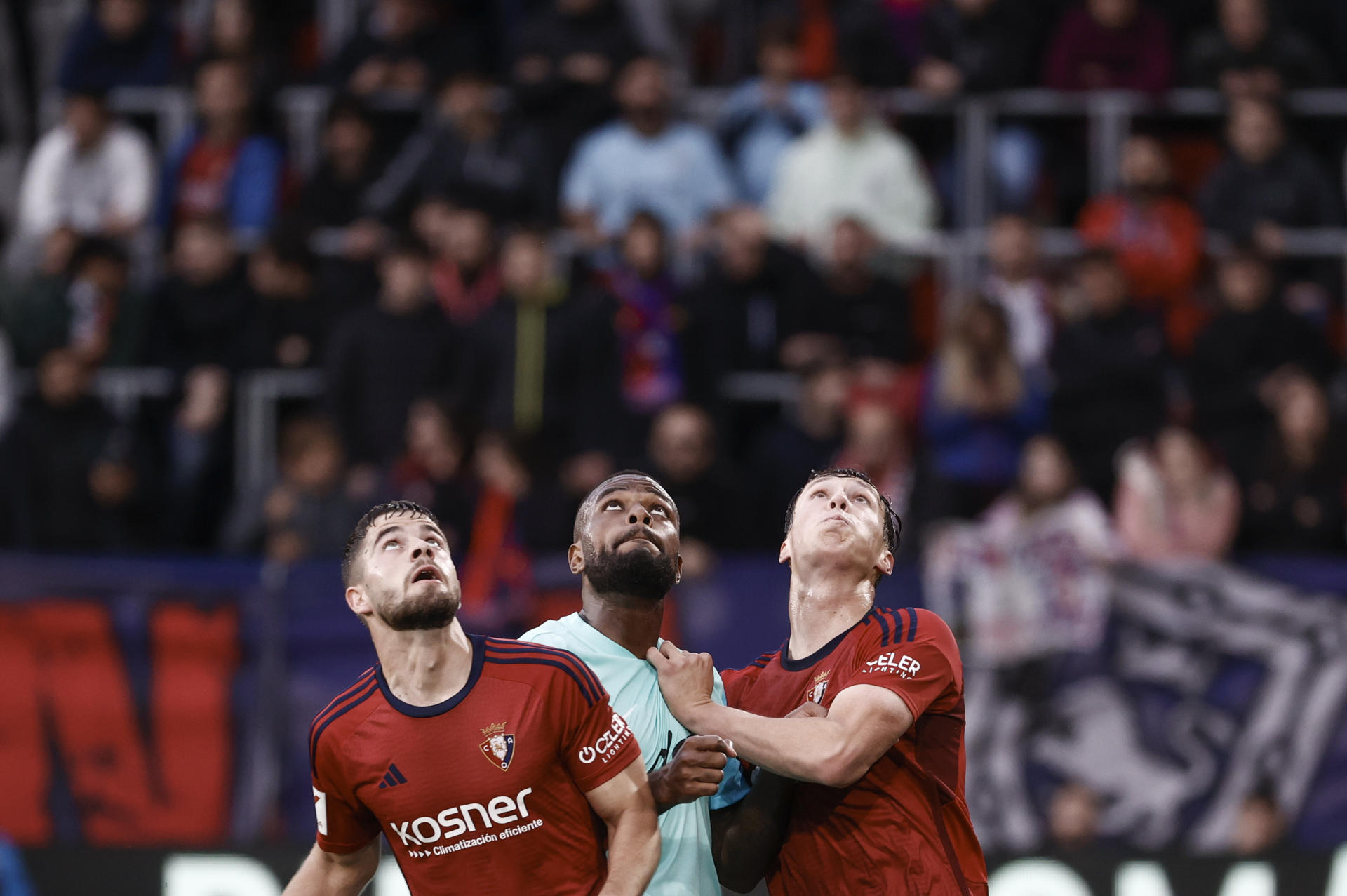 Los jugadores de Osasuna Iker Muñoz (i) y Jorge Herrando (d) disputan el balón ante Cyle Larin (c), delantero canadiense del Mallorca, durante el encuentro de la jornada 36 de LaLiga EA Sports entre CA Osasuna y RCD Mallorca, este martes en el Estadio El Sadar, en Pamplona. EFE/Jesús Diges 
