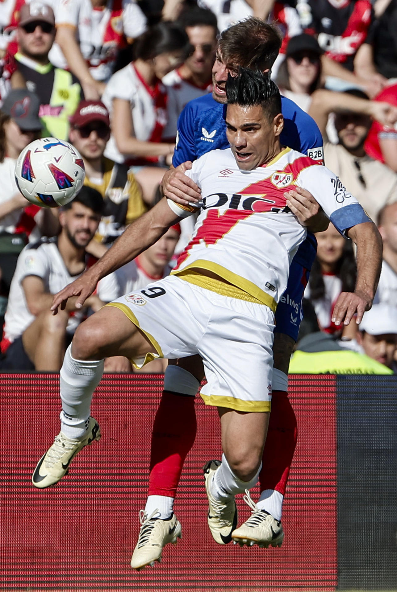 El delantero colombiano del Rayo Vallecano Radamel Falcao (delante) lucha con Yeray Álvarez, del Athletic Club, durante el partido de la jornada 38 de LaLiga EA Sports en el estadio de Vallecas. EFE/ Sergio Pérez