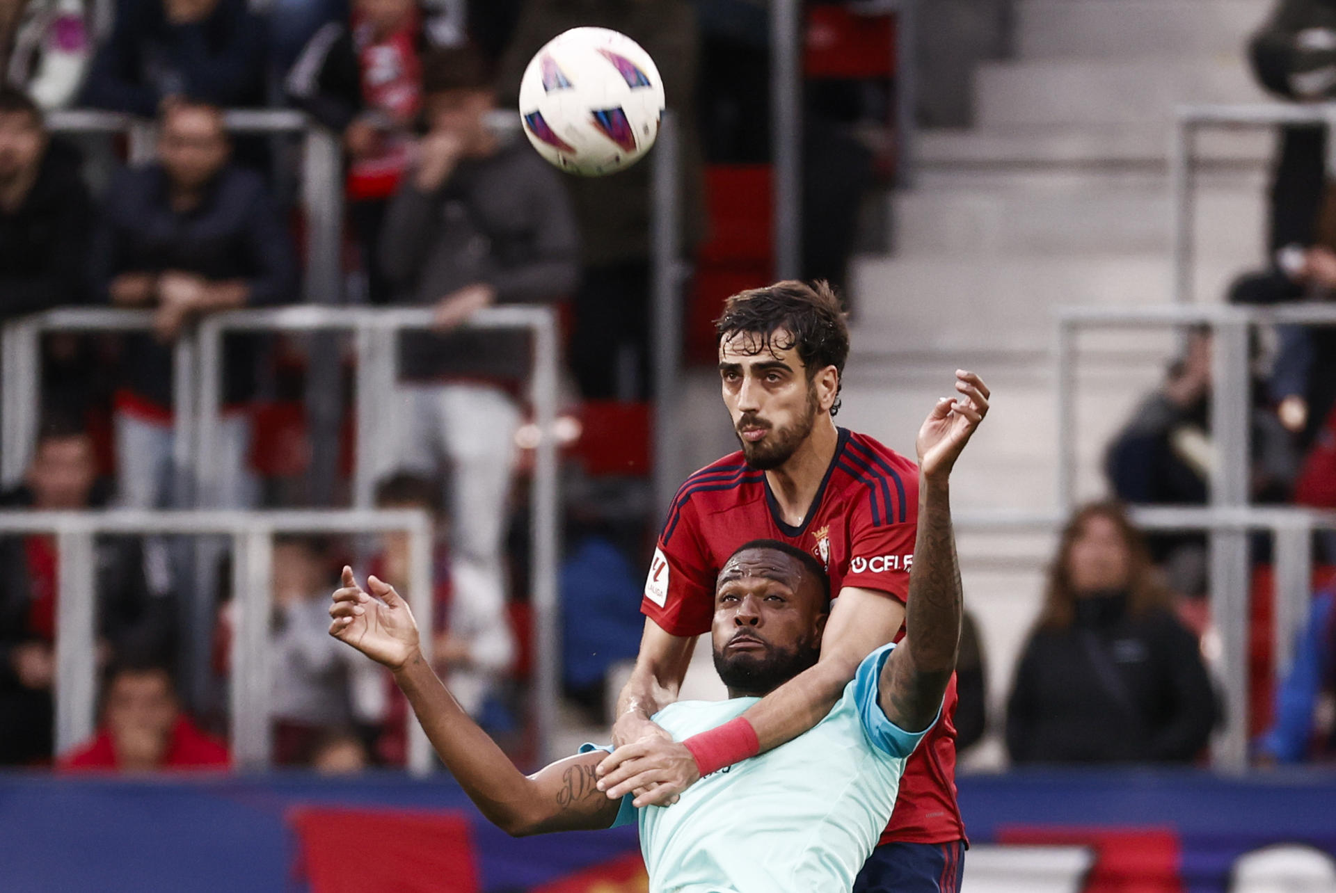 El defensa de Osasuna Alejandro Catena (d) disputa el balón ante Cyle Larin (i), delantero canadiense del Mallorca, durante el encuentro de la jornada 36 de LaLiga EA Sports entre CA Osasuna y RCD Mallorca, este martes en el Estadio El Sadar, en Pamplona. EFE/Jesús Diges 