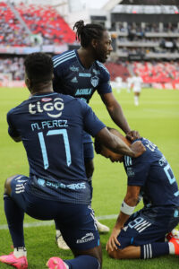 El delantero José Enamorado (d) celebra con dos compañeros el gol de Junior de Barranquilla a Liga de Quito en partido de la quinta jornada del Grupo E de la Copa Libertadores jugado este martes en el estadio Rodrigo Paz Delgado de la capital ecuatoriana. EFE/ José Jácome