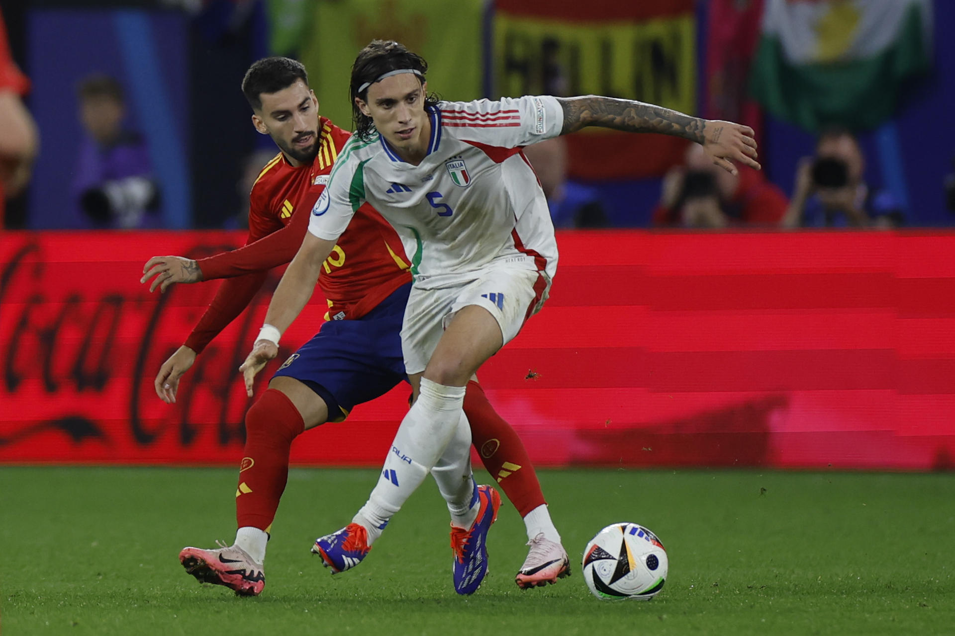 El defensa de la selección italiana, Ricardo Calafiori (d), intenta controlar el balón ante el centrocampista de la selección española, Alex Baena, durante el encuentro de la fase de grupos de la Eurocopa 2024 que España e Italia disputan hoy jueves en el Arena AufSchalke, Gelsenkirchen (Alemania). EFE/Alberto Estévez. 