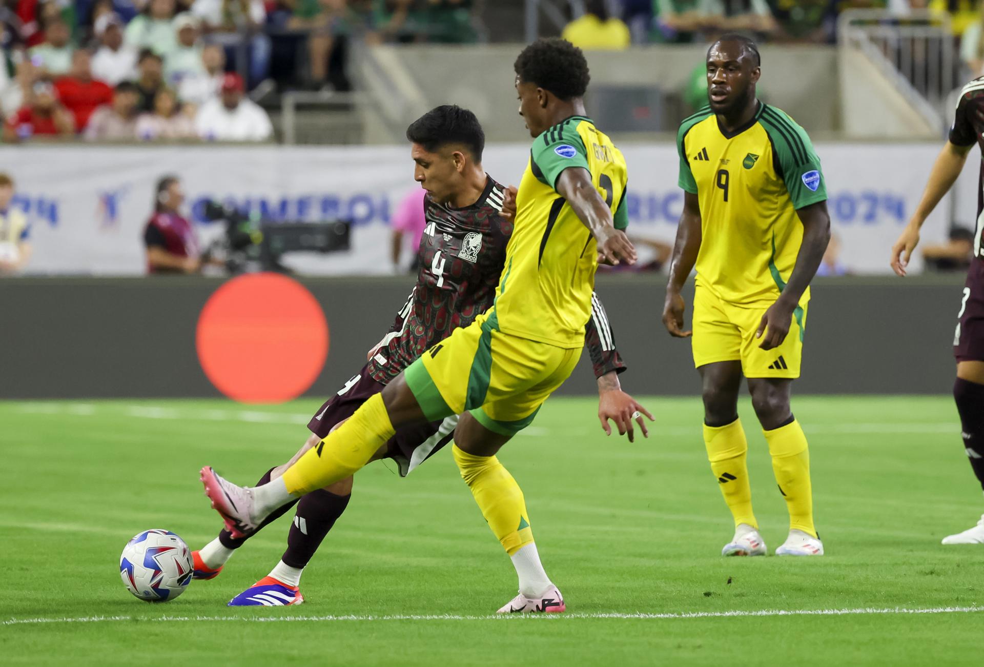 El delantero jamaiquino Demarai Gray fue registrado este sábado, 22 de junio, al intentar impedir un disparo del capitán mexicano, Edson Álvarez (i), durante el segundo partido del grupo B de la Copa América, en el NRG Stadium de Houston (Texas, EE.UU.). Álvarez salio lesionado al minuto 30. EFE/Leslie Plaza 