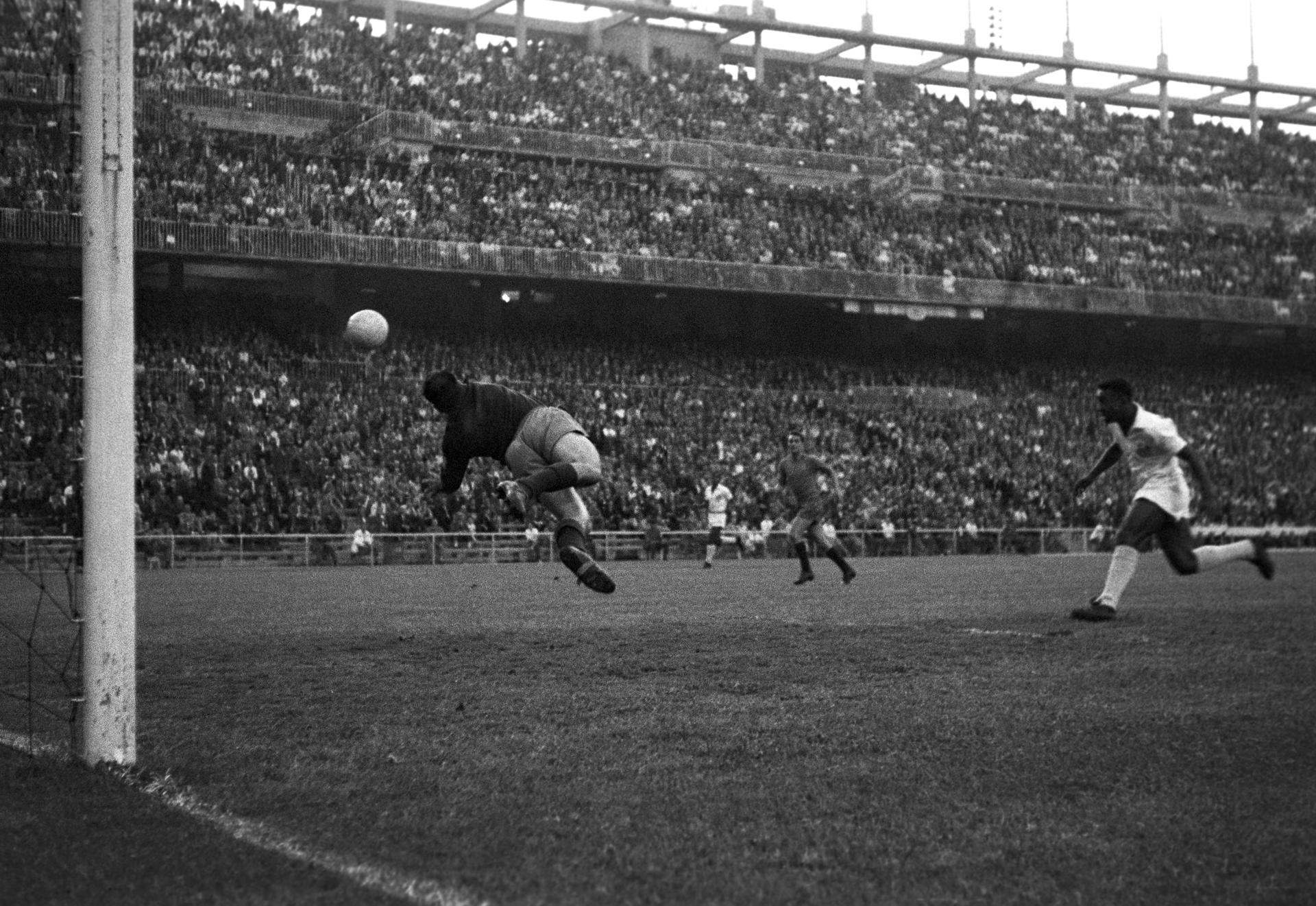 Fotografía de archivo, tomada el 17 de junio de 1959, en la que se registró al desaparecido futbolista brasileño Edson Arantes do Nascimento "Pelé" (d), al disparar a puerta, durante un partido de exhibición entre el club Santos de Brasil y el Real Madrid, en el estadio Santiago Bernabéu de Madrid (España). EFE/jn 