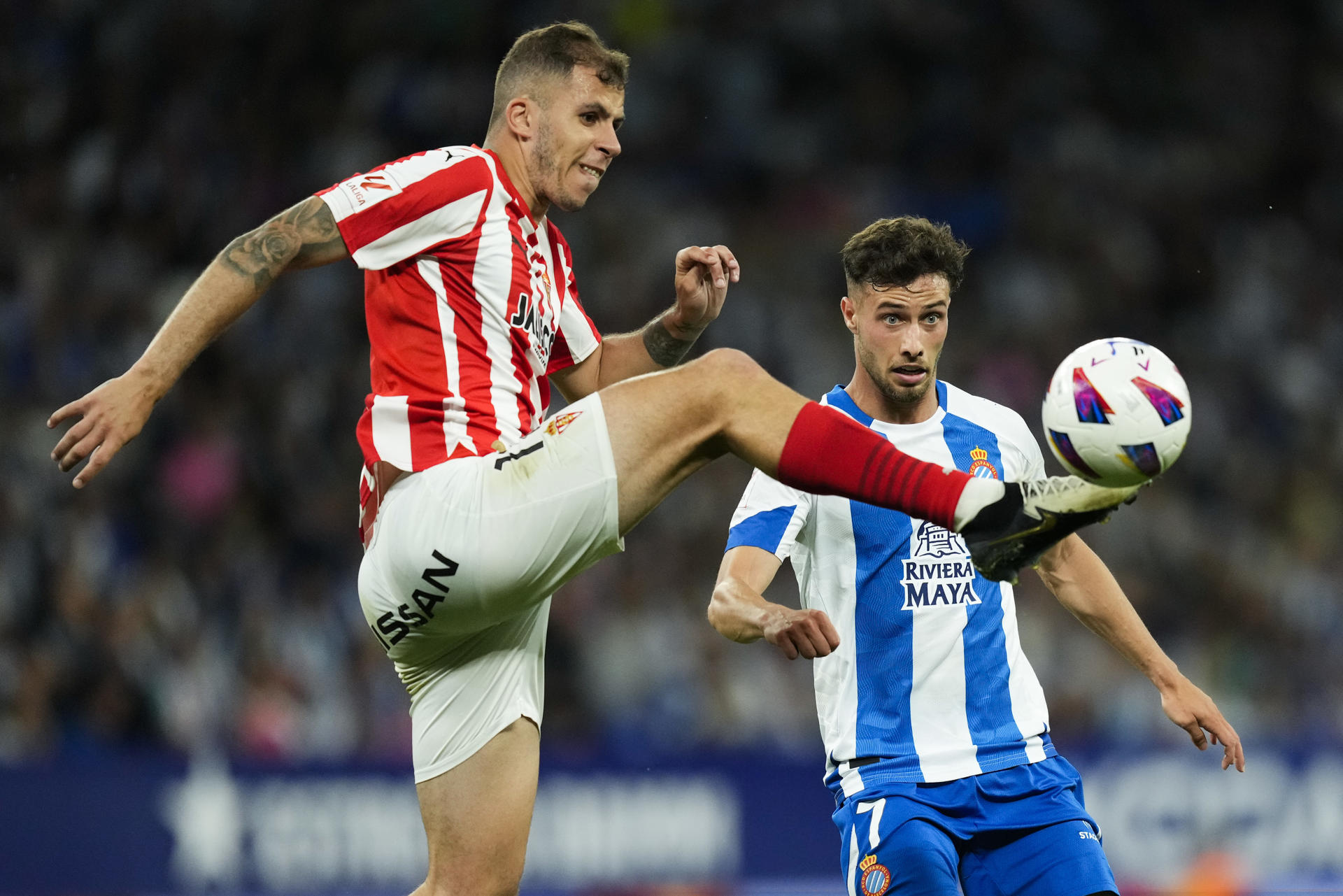 El delantero del Espanyol Javi Puado (d) y el centrocampista del Sporting Cristian Rivera durante el partido de vuelta de la primera eliminatoria de ascenso a Primera División, este jueves en el Stage Front Stadium. EFE/ Enric Fontcuberta