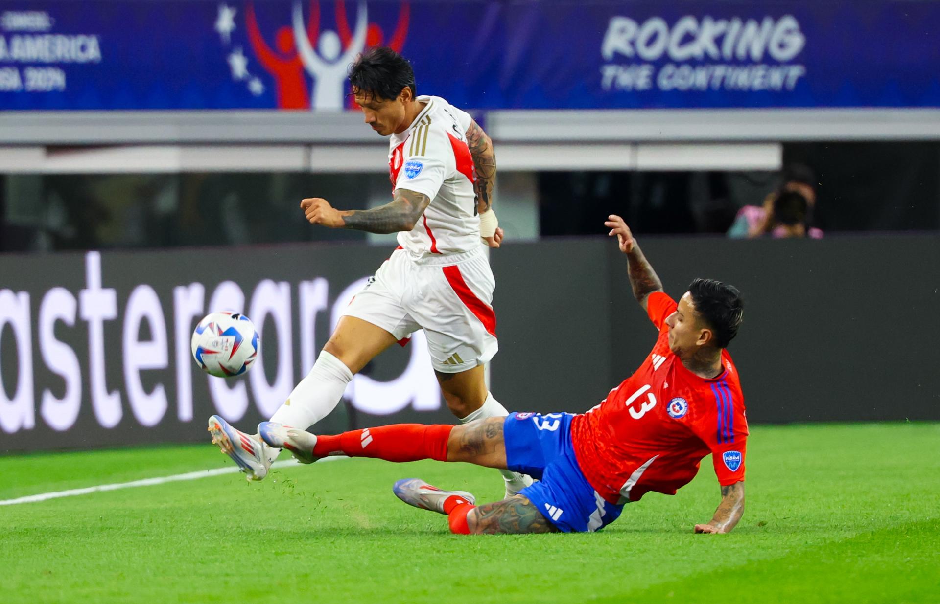 El centrocampista chileno Erick Pulgar (d) fue registrado este viernes, 21 de junio, al intentar impedir el avance del atacante peruano Gianluca Lapadula (i), durante un partido de la primera jornada del grupo A de la Copa América, en el estadio AT&T de Arlington (Texas, EE.UU.). EFE/Kevin Jairaj 