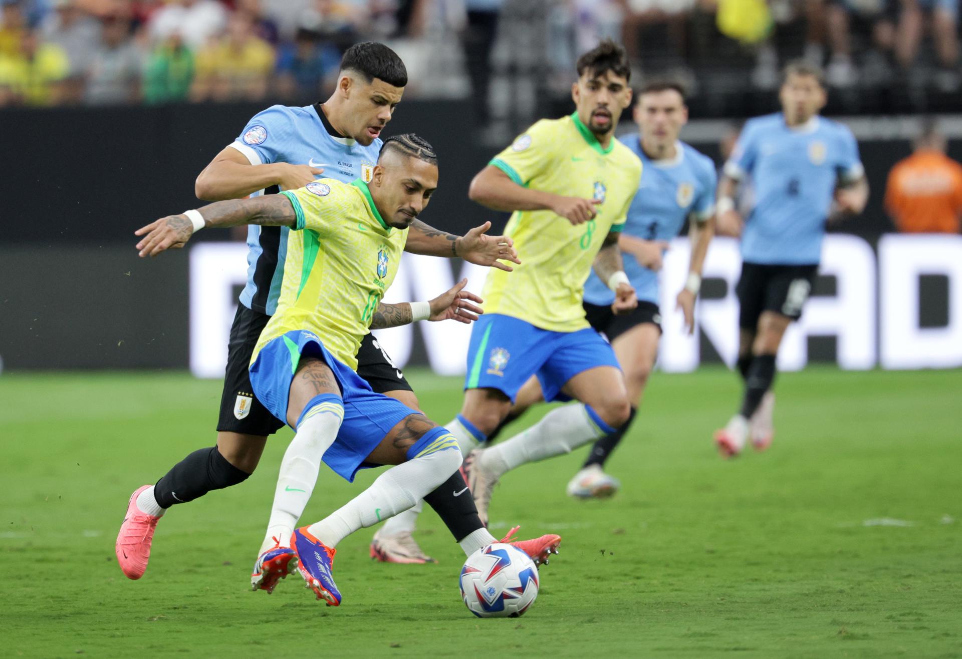 Raphinha Dias de Brasil (C) en acción contra Maximiliano Araujo de Uruguay (i) durante un partido de la Copa América 2024. EFE/EPA/ALLISON DINNER 