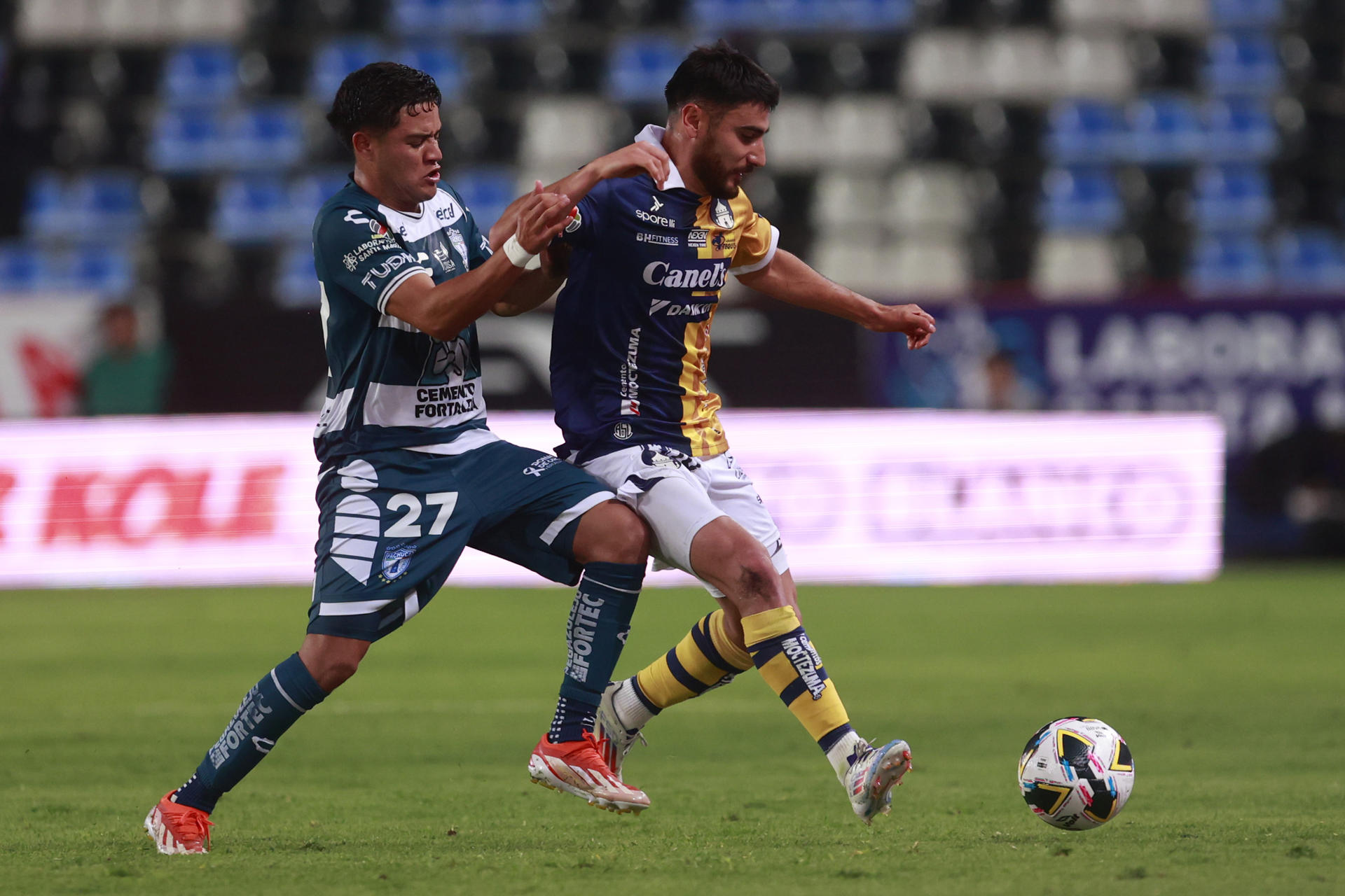 Owen González (i) de Pachuca disputa el balón con Aldo Cruz de San Luis este martes, durante el partido de la jornada 3 del torneo Apertura 2024 del fútbol mexicano, celebrado en el estadio Hidalgo de Pachuca (México). EFE/ David Martínez Pelcastre 