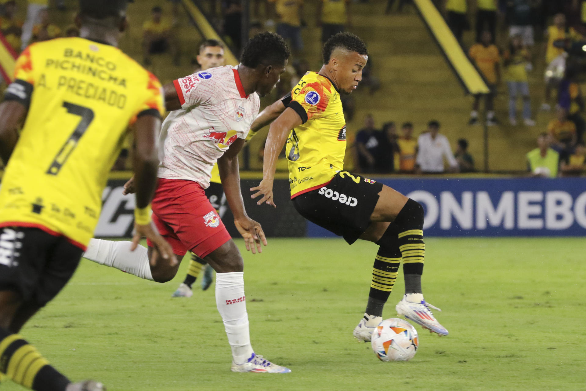 Byron Castillo (d), del Barcelona de Ecuador, fue registrado este miércoles, 17 de julio, al disputar un balón con Henry Mosquera (c), del Bragantino de Brasil, durante el partido de ida de esta llave de los 'playoff' para acceder a los octavos de final de la Copa Sudamericana, en el estadio Monumental de Guayaquil (Ecuador). EFE/Jonathan Miranda 