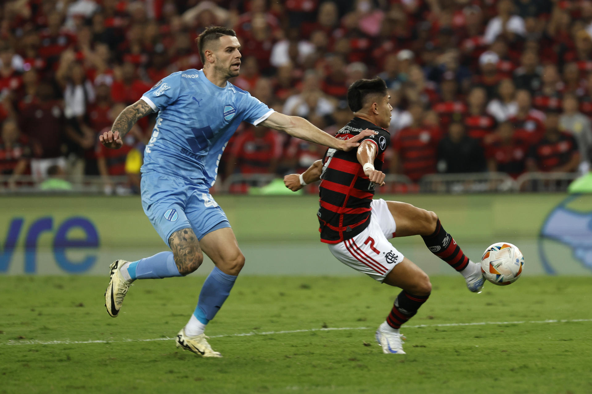 Luiz Araújo (d), de lanero de Flamengo, fue registrado este jueves, 14 de agosto, al patear un balón que convertiría en gol ante Bolívar, durante el partido de ida de esta lleva de los octavos de final de la Copa Libertadores, en el estadio de Maracaná de Río de Janeiro (Brasil). EFE/Antonio Lacerda 