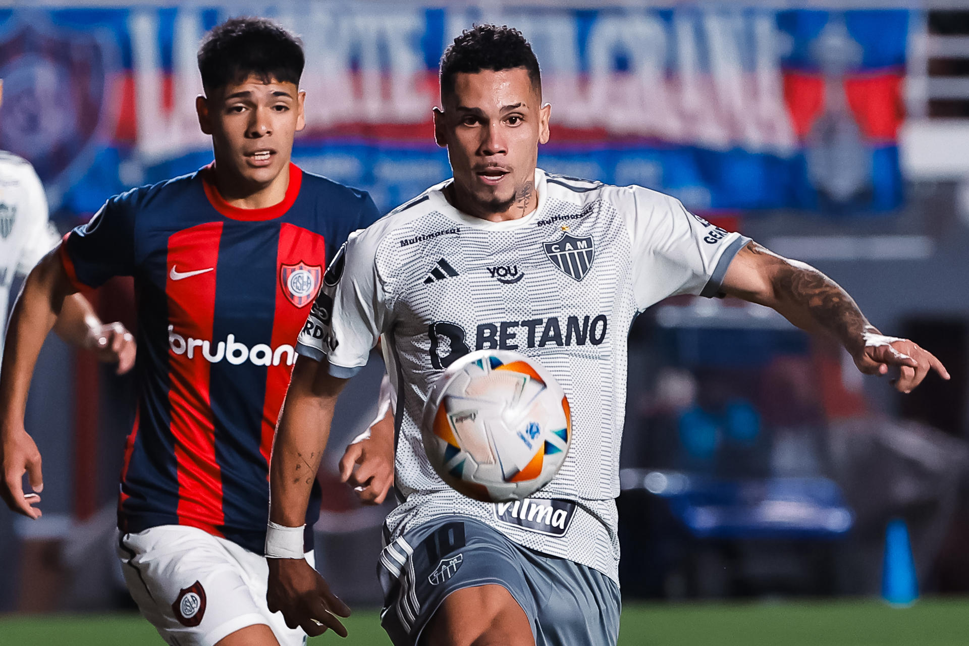 Nahuel Arias (i), de San Lorenzo de Argentina, fue registrado este martes, 13 de agosto, al disputar un balón con Paulinho, delantero del Atlético Mineiro de Brasil, durante el partido de ida de esta llave de los octavos de final de la Copa Libertadores, en el estadio Pedro Bidegaín de Buenos Aires (Argentina). EFE/Juan Ignacio Roncoroni 