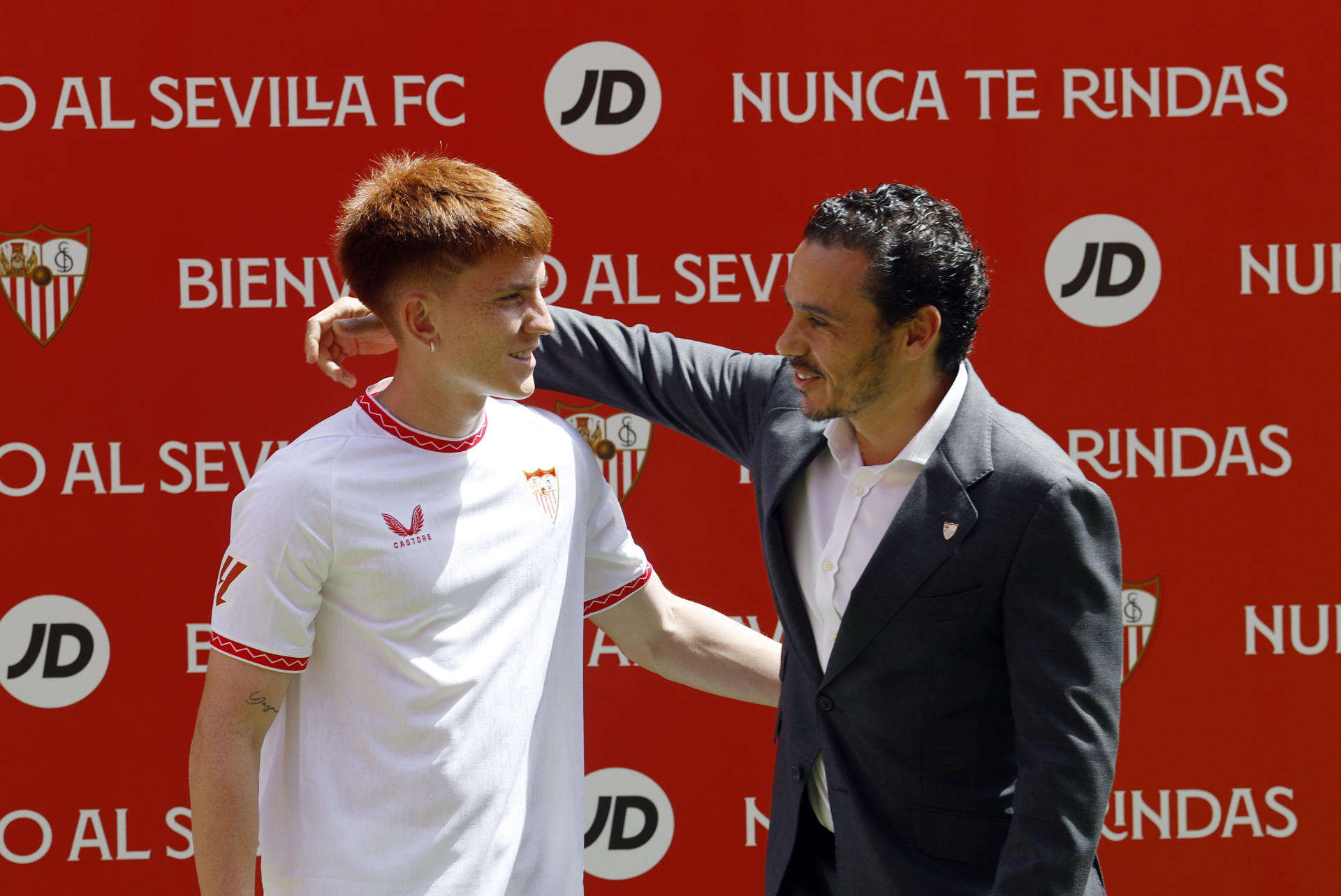 GRAFAND3238. SEVILLA, 30/08/2024.-El lateral izquierdo argentino Valentín Barco (i), es abrazado por el presidente del Sevilla FC, Jose Maria del Nido Carrasco, durante la presentación como último refuerzo del club sevillista, al que ha llegado cedido por el Brighton inglés, este viernes en el estadio Ramón Sánchez-Pizjuán de la capital hispalense. EFE/Julio Muñoz 