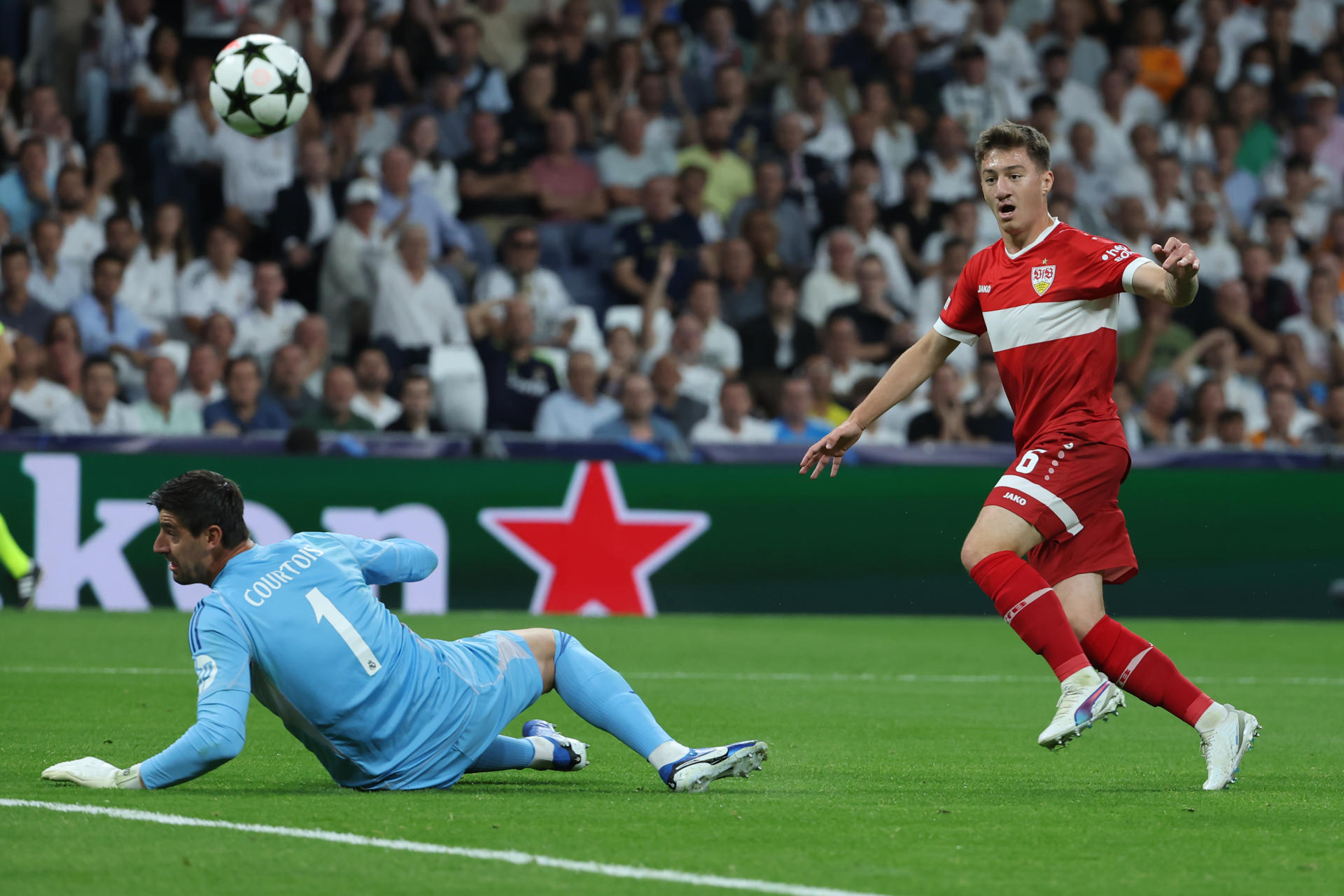 El guardameta belga del Real Madrid, Thibaut Courtois (i), tras detener el remate del centrocampista del Vfb Stuttgart, Angelo Stiller, durante el encuentro correspondiente a la primera jornada de la Liga de Campeones en el estadio Santiago Bernabéu, en Madrid. EFE / Kiko Huesca. 