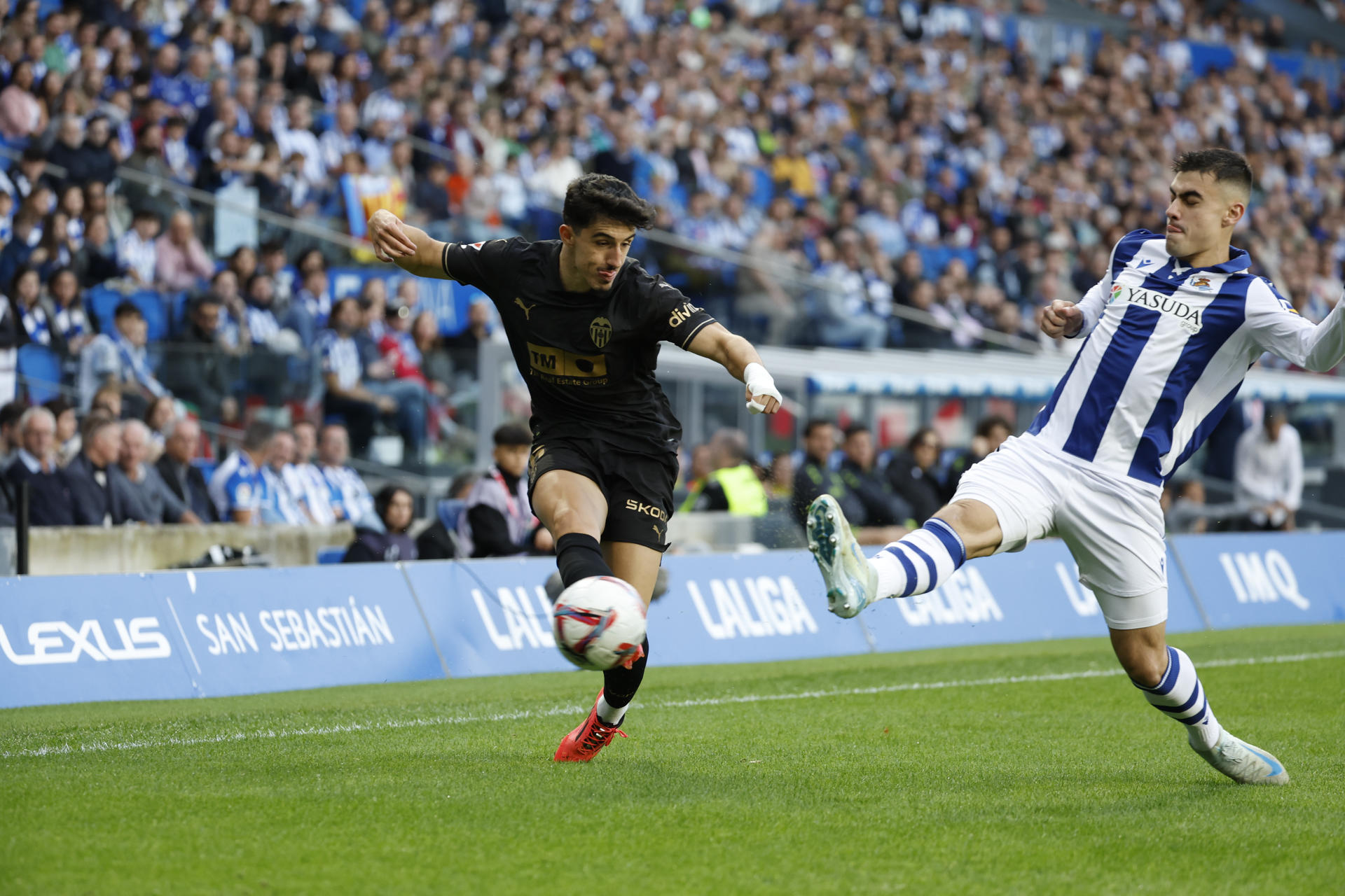 El centrocampista del Valencia Diego López (i) juega un balón ante Ander Barrenetxea, de la Real Sociedad. durante el partido de LaLiga en Primera Divisiónen el Reale Arena, en San Sebastián. EFE/Javier Etxezarreta
