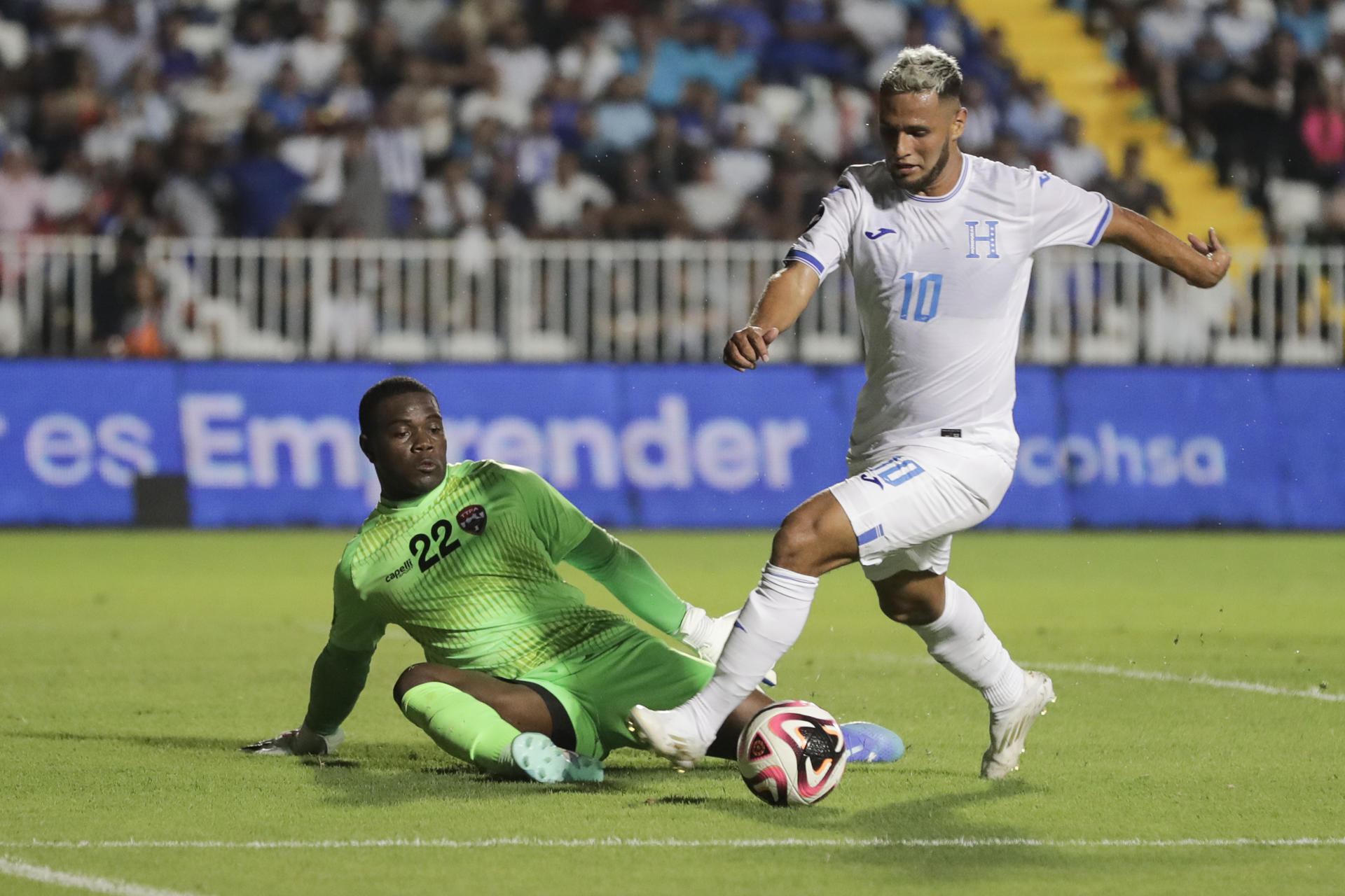 El hondureño Alexander Agustín López (d) sostiene un mano a mano con el portero de Trinidad y Tobago, Denzil Smith, este viernes durante el partido de la primera fecha de la Liga de Naciones de la Concacaf jugado en el estadio Nacional 'Chelato Ucles' de Tegucigalpa. EFE/Gustavo Amador 