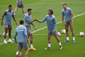 Griezmann y Giménez se saludan, junto a Llorente y Reinildo, durante el entrenamiento de este sábado.-EFE/ Víctor Lerena