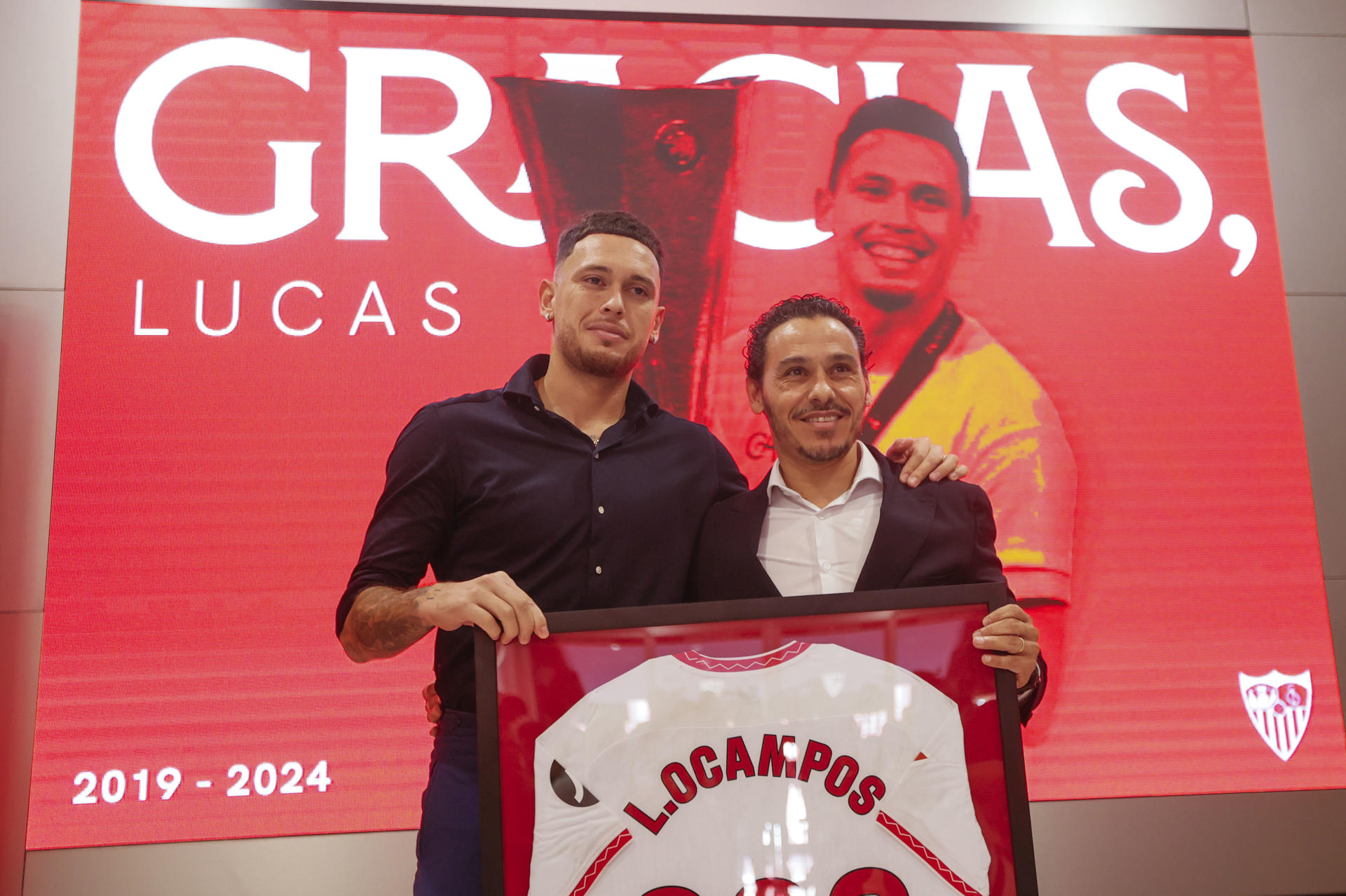 El jugador argentino Lucas Ocampos (d) sostiene una camiseta conmemorativa junto al presidente del Sevilla, José María del Nido, durante su acto de despedida este martes.EFE/ José Manuel Vidal