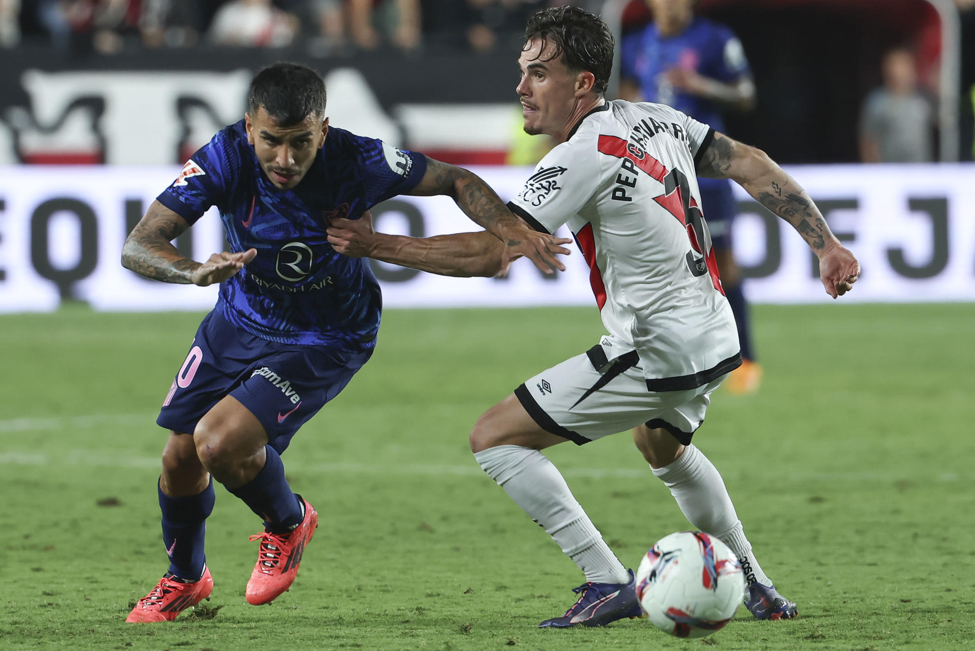 El delantero argentino del Atlético de Madrid, Ángel Correa (i), disputa el balón ante el defensa del Rayo Vallecano, Pep Chavarría, durante el encuentro correspondiente a la sexta jornada de Laliga EA Sports que disputaron Rayo Vallecano y Atlético de Madrid en el estadio de Vallecas, en Madrid. EFE / Kiko Huesca. 