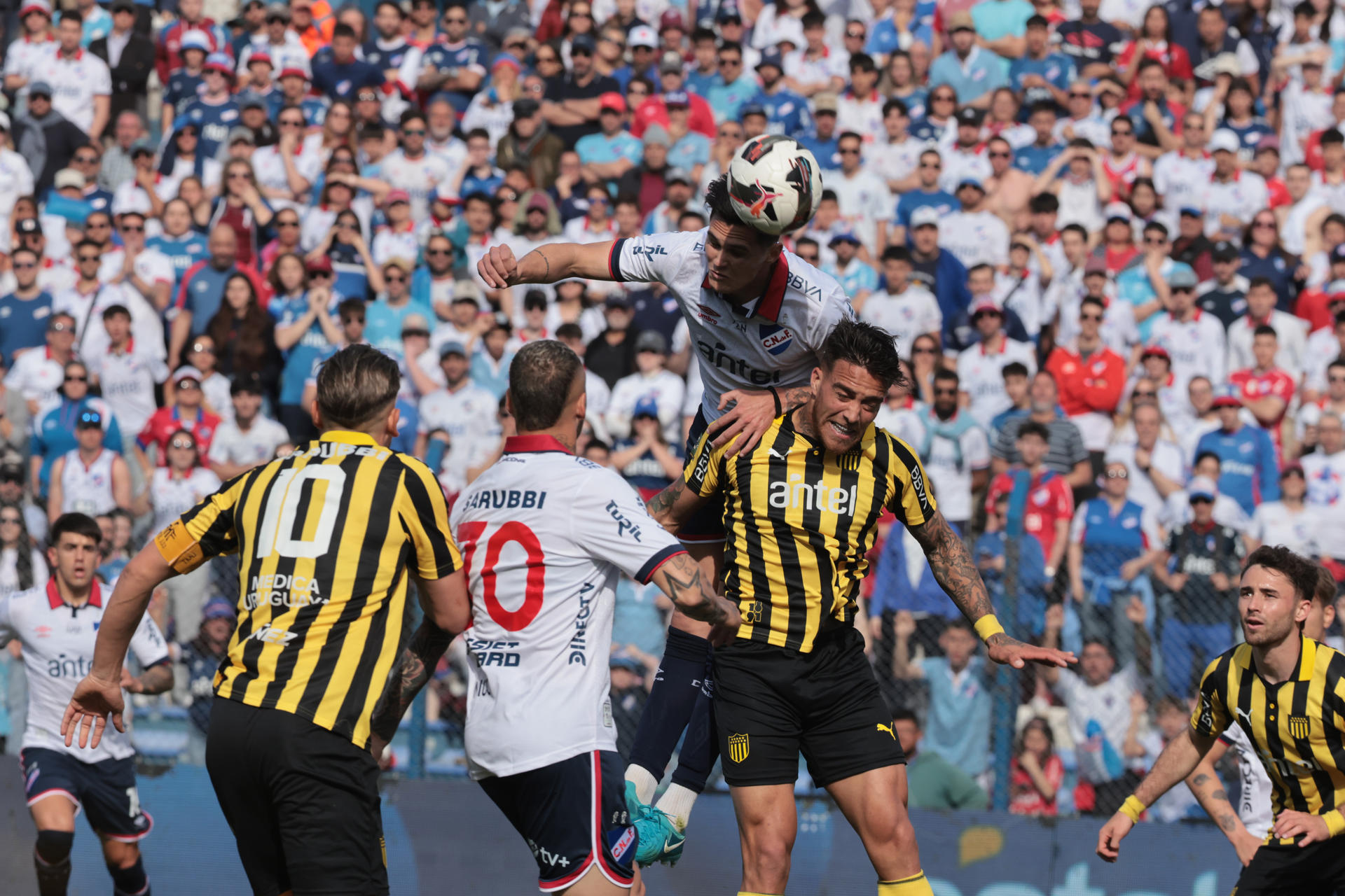 Ruben Bentancourt (arriba) de Nacional disputa un balón con Javier Cabrera de Peñarol. EFE/ Gaston Britos 