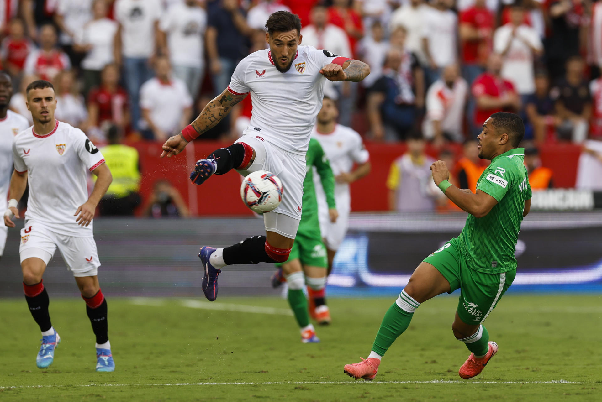 El centrocampista serbio del Sevilla Nemanja Gudelj (c) ante el delantero brasileño del Real Betis, Vitor Hugo Roque (d), durante el partido de la novena jornada de Liga en el estadio Ramón Sánchez-Pizjuán de Sevilla. EFE/Julio Muñoz 