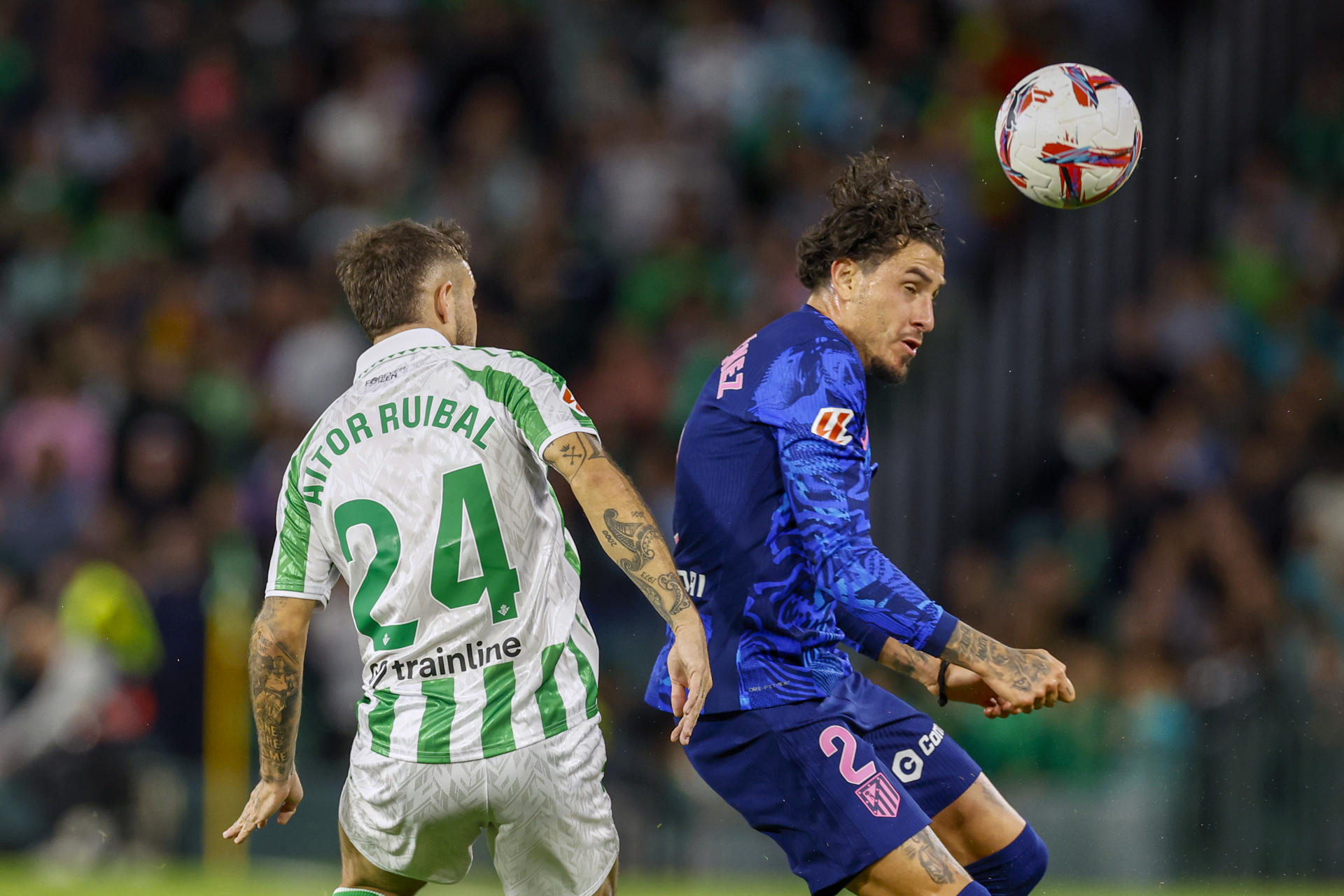 El defensa español del Betis Aitor Ruibal (i) disputa un balón con el defensa uruguayo del Atlético de Madrid José María Giménez (d) durante el encuentro correspondiente a la jornada 11 de Laliga EA Sports que disputan hoy domingo Betis y Atlético de Madrid en el estadio Benito Villamarin, en Sevilla. EFE/ Julio Muñoz 