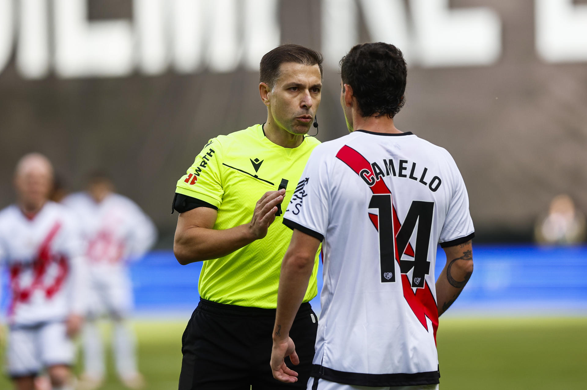 El delantero del Rayo Vallecano Sergio Camello (d) habla con el árbitro del partido Adrián Cordero Vega este sábado, durante el partido de la jornada 11de LaLiga EA Sports, entre el Rayo Vallecano y el Alavés, en el Estadio de Vallecas, en Madrid. EFE/ Rodrigo Jiménez 