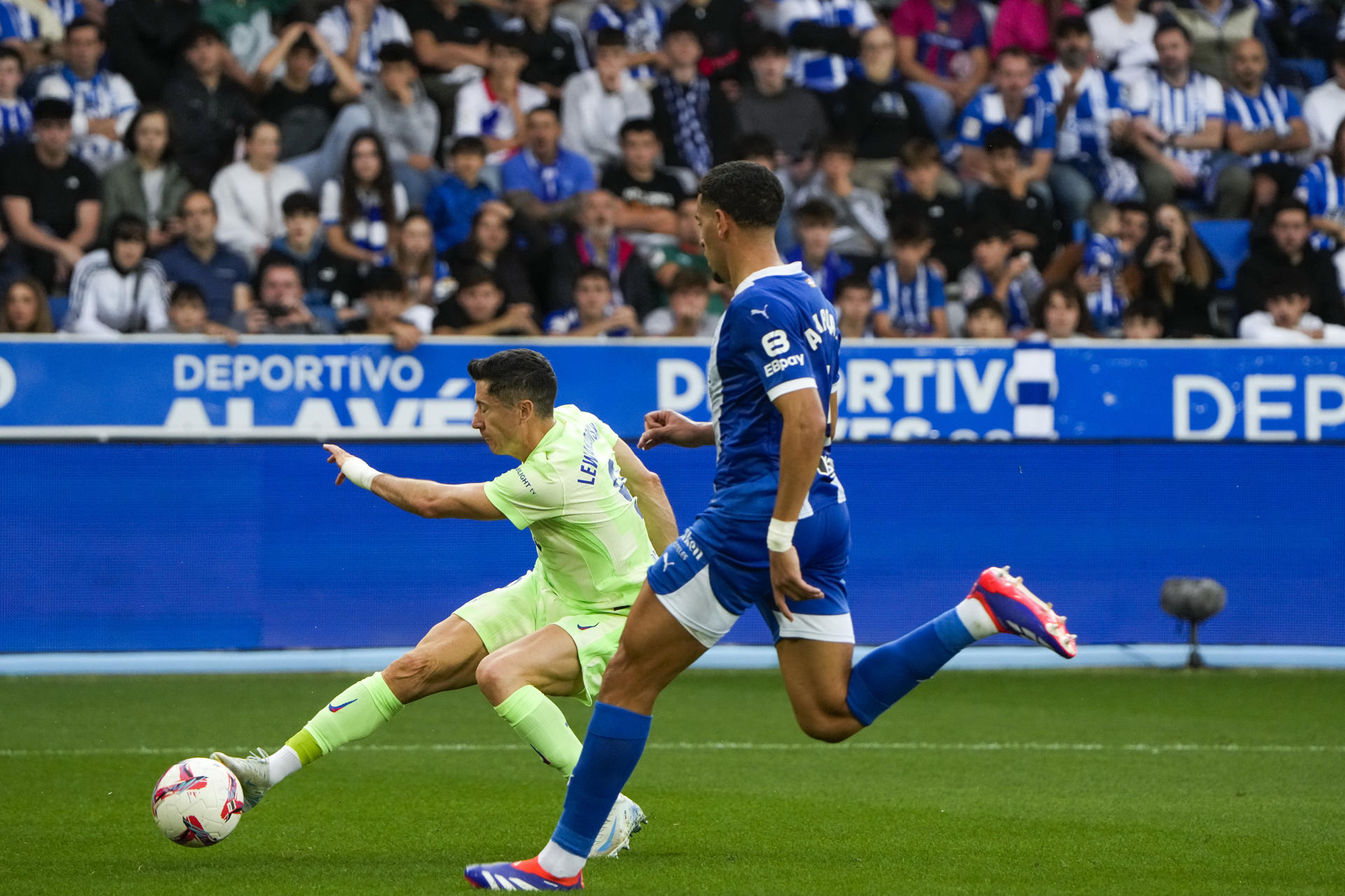 El delantero polaco del FC Barcelona Robert Lewandowski (i) dispara a puerta ante el Alavés durante el partido de la novena jornada de Liga entre  Alavés y Barcelona en el estadio de Mendizorrotza de Vitoria. EFE/Adrián Ruiz de Hierro
