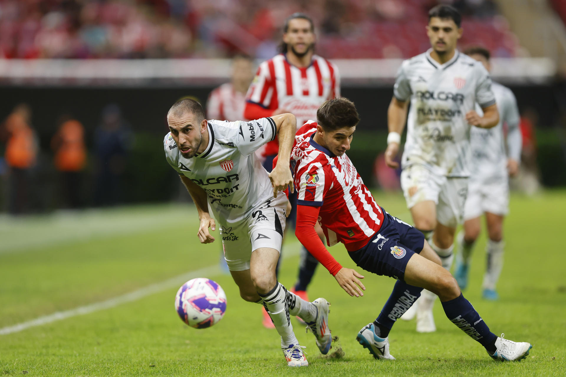 Isaac Brizuela (d) del Guadalajara disputa el balón con Manuel Mayorga de Necaxa este martes durante un partido de la jornada 13 del torneo apertura 2024 de la liga del fútbol mexicano disputado en el Estadio Akron en la ciudad de Guadalajara, Jalisco (México). EFE/ Francisco Guasco 