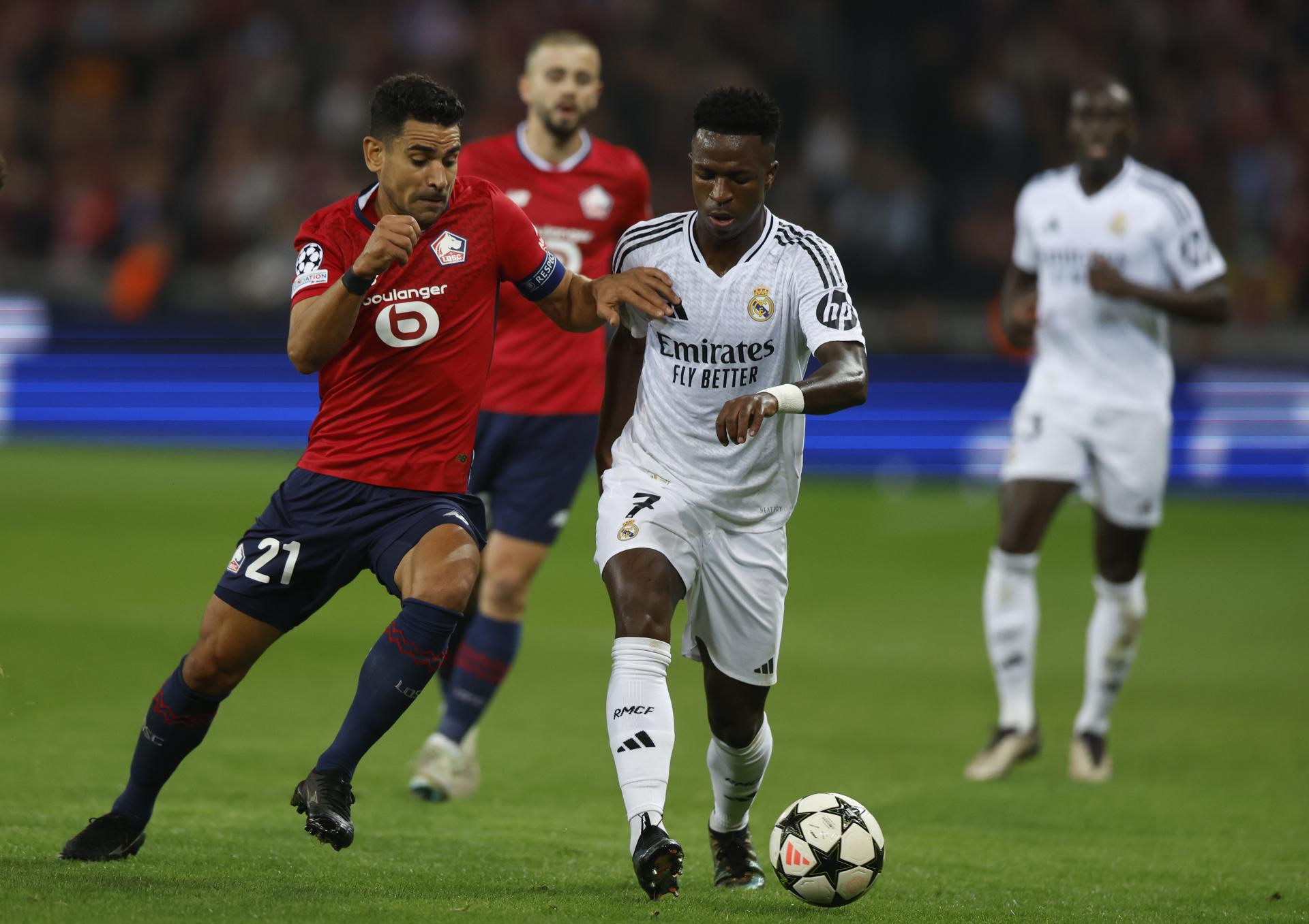 El jugador del Lille Benjamin Andre (I) ante Vinicius Junior, del Real Madrid, durante el partido de la segunda jornada de la Liga de Campeones que juegan Lille y Real Madrid en Lille, Francia. EFE/EPA/MOHAMMED BADRA 