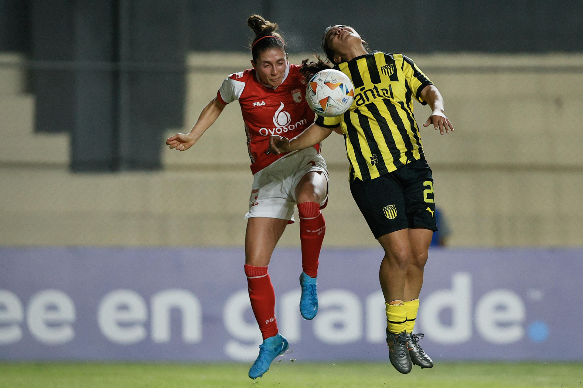 La jugadora de Peñarol Sasha Larrea Tregartten (d) disputa este viernes el balón con la centrocampista de Santa Fe Natalia Gaián en el debut sin goles de ambos equipos en la Copa Libertadores, cuyo partido se jugó en el estadio asunceno Arsenio Erico. EFE/ Juan Pablo Pino 