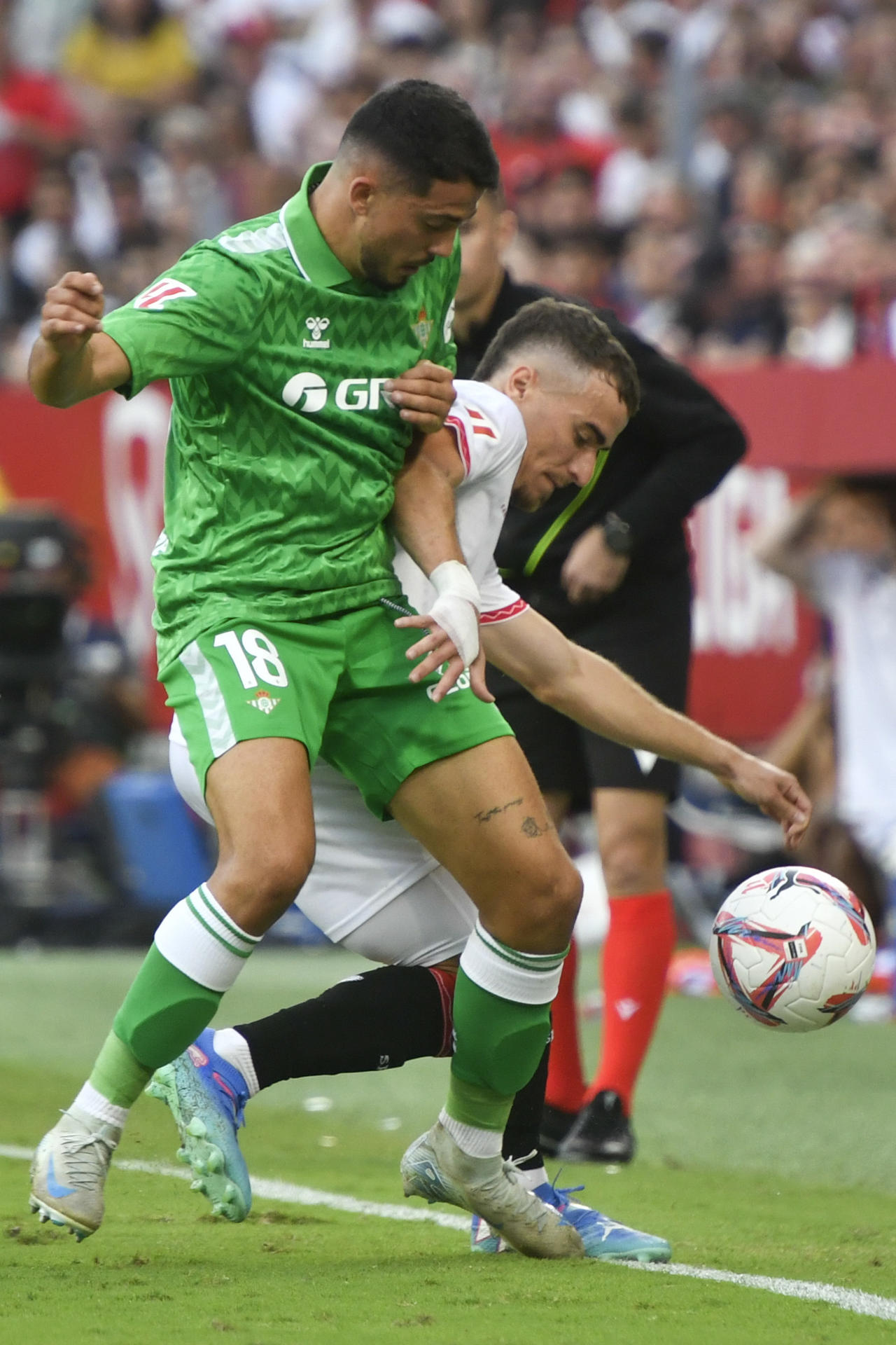 El defensa del Sevilla Adrià Pedrosa (d) lucha con Pablo Fornals, del Betis, durante el partido de la novena jornada de LaLiga en el estadio Ramón Sánchez-Pizjuán, en Sevilla. EFE/Raúl Caro. 