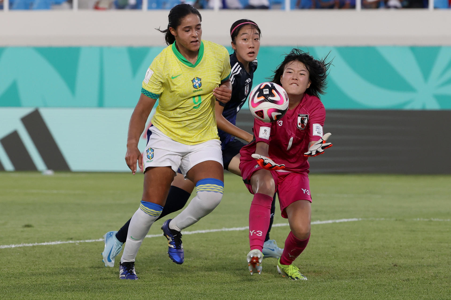 La portera Mao Fukuda intenta asegurar el balón ante el acecho de Juliana 'Juju' Melo, de Brasil. EFE/ Orlando Barría 